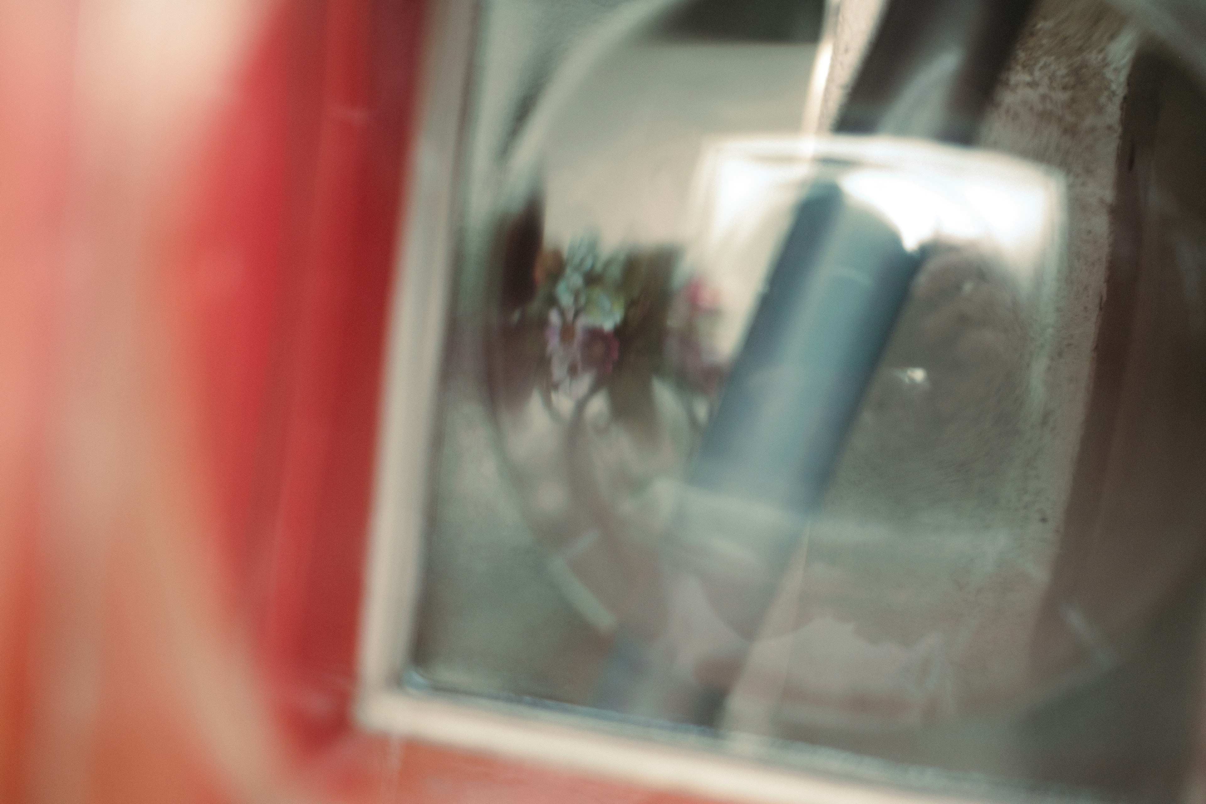 Blurred view of scenery and reflection through a red car window