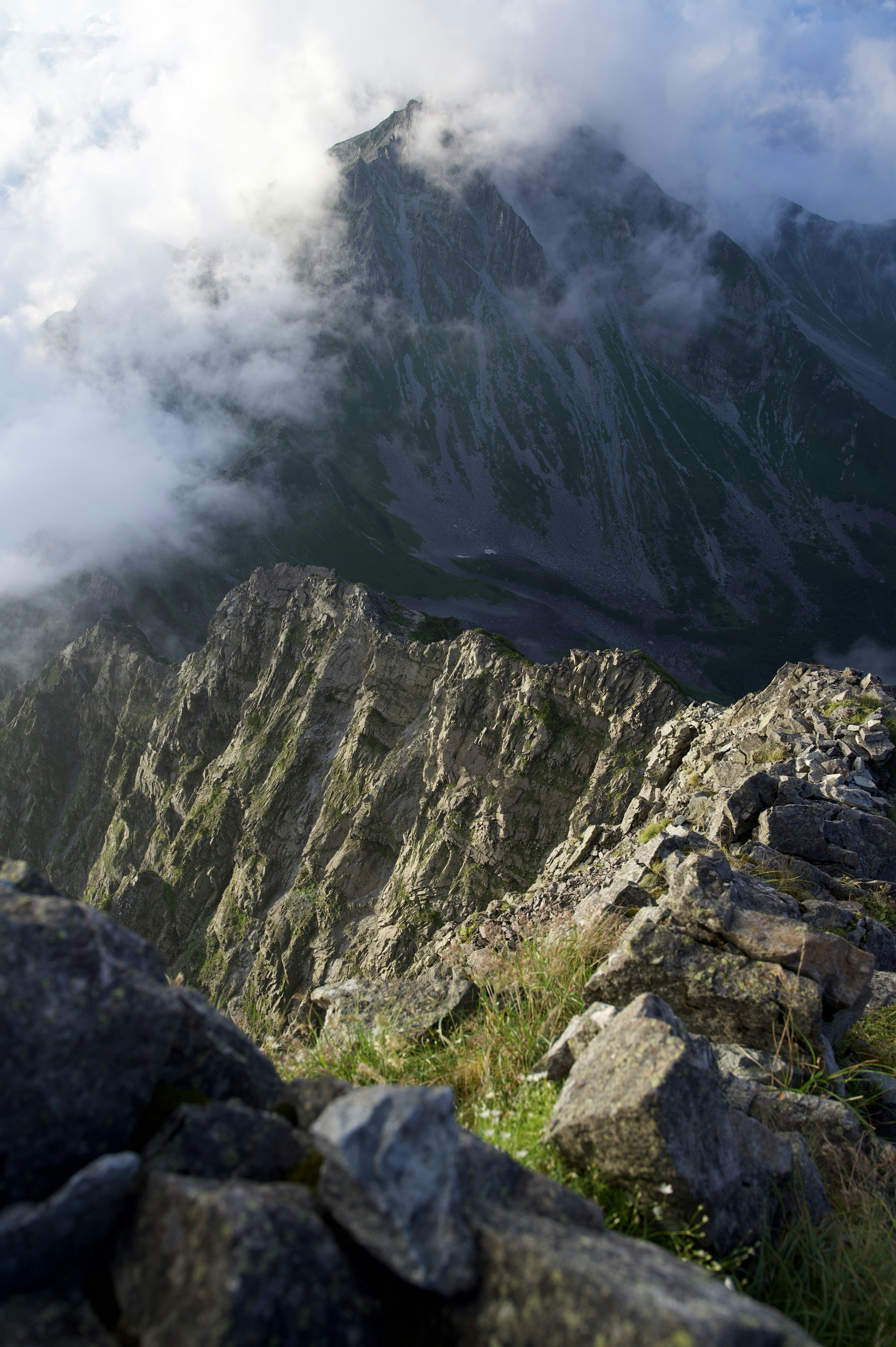 Berglandschaft in Wolken gehüllt mit steilen Felsabhängen