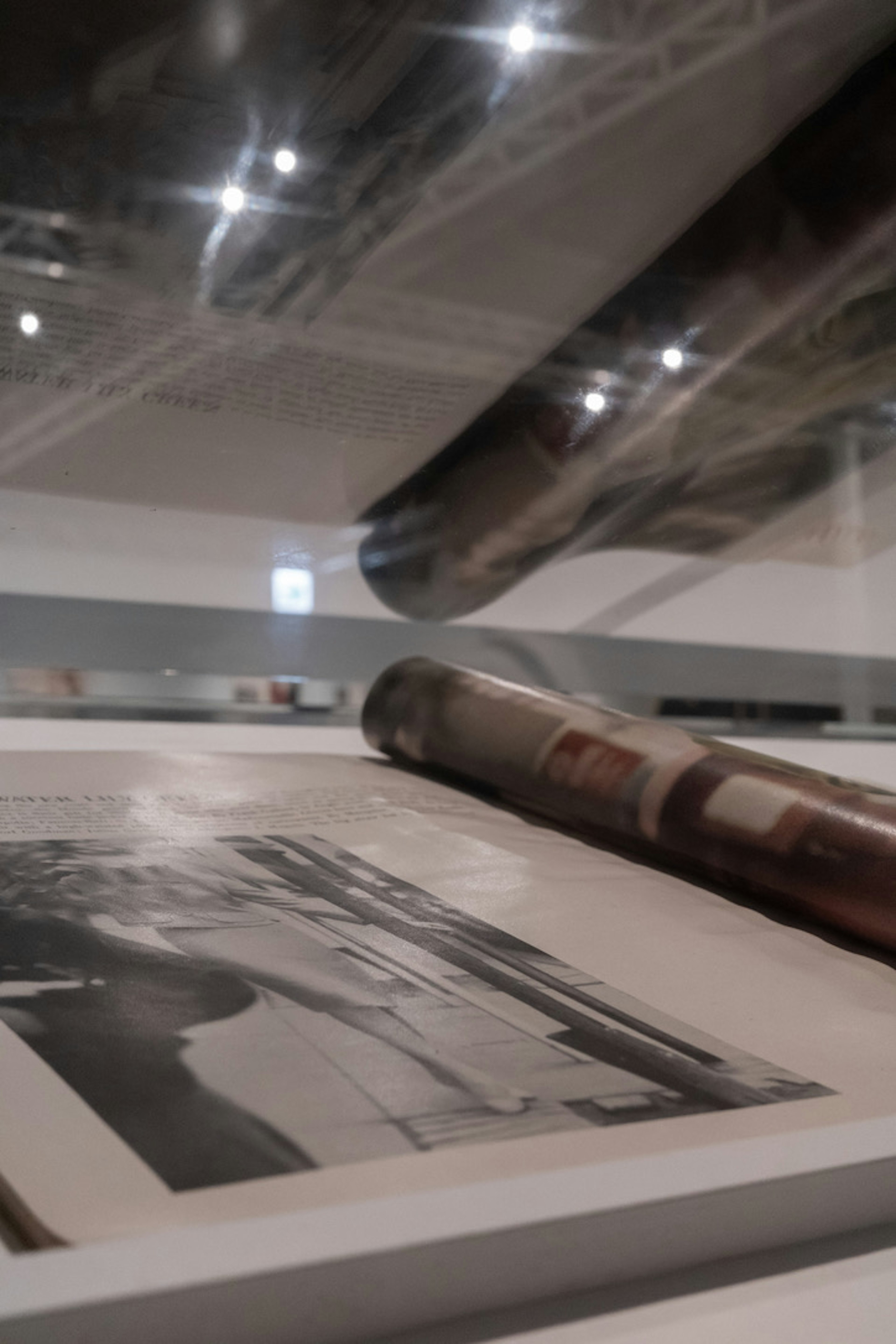 Interior de un espacio de exhibición con una fotografía antigua y impresiones enrolladas