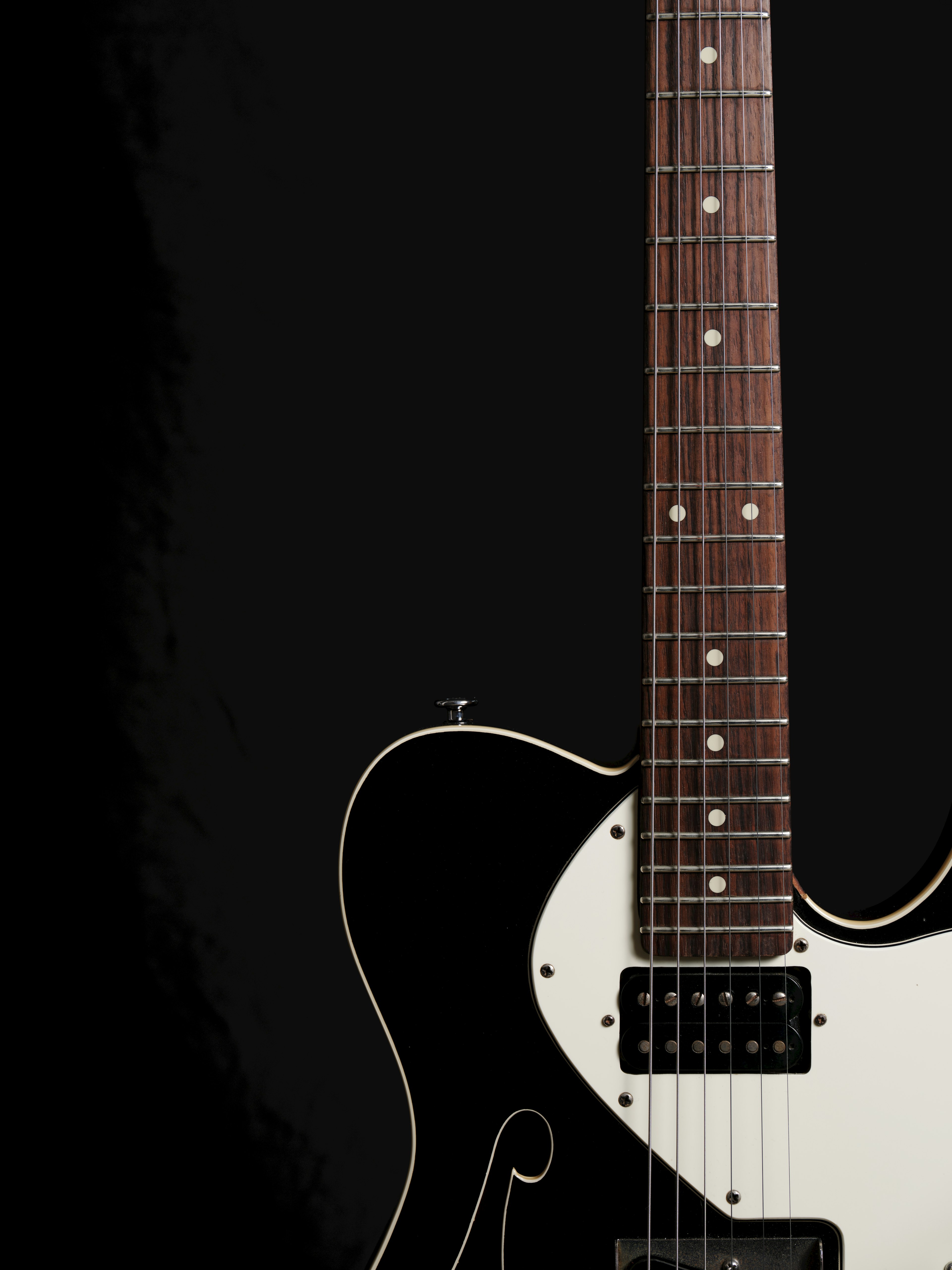 Close-up of an electric guitar against a black background