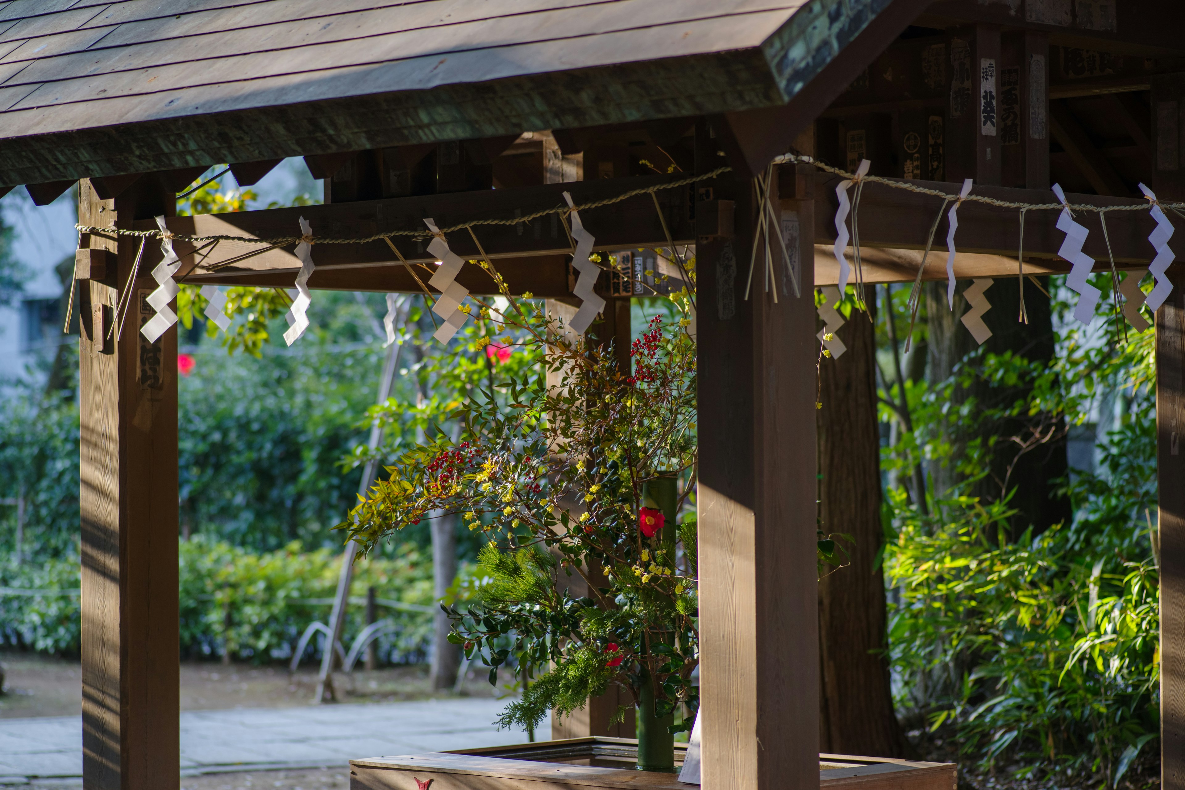 Structure en bois dans un sanctuaire avec des décorations blanches ressemblant à des talismans