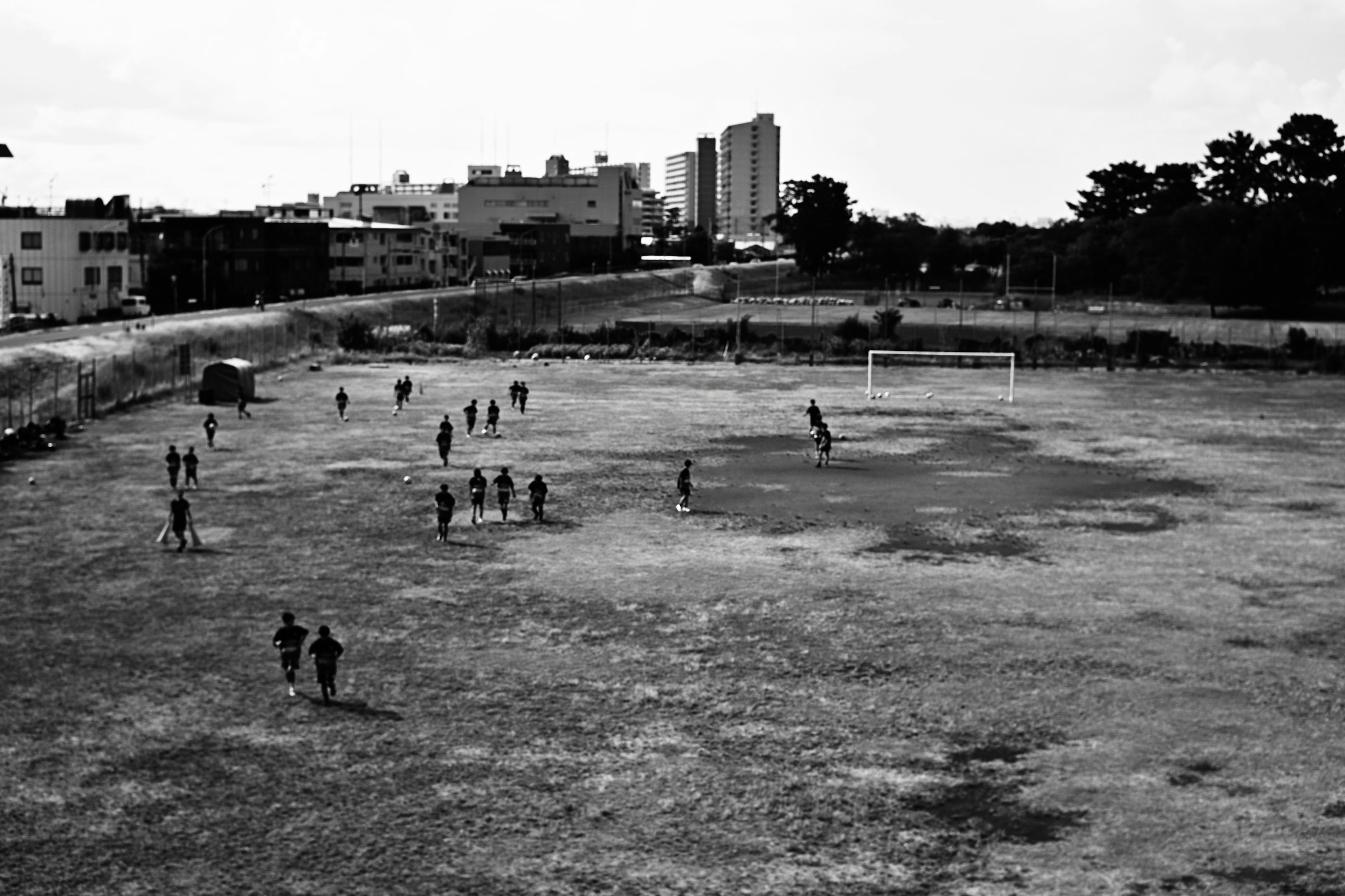 Una escena de personas jugando al fútbol en un campo árido