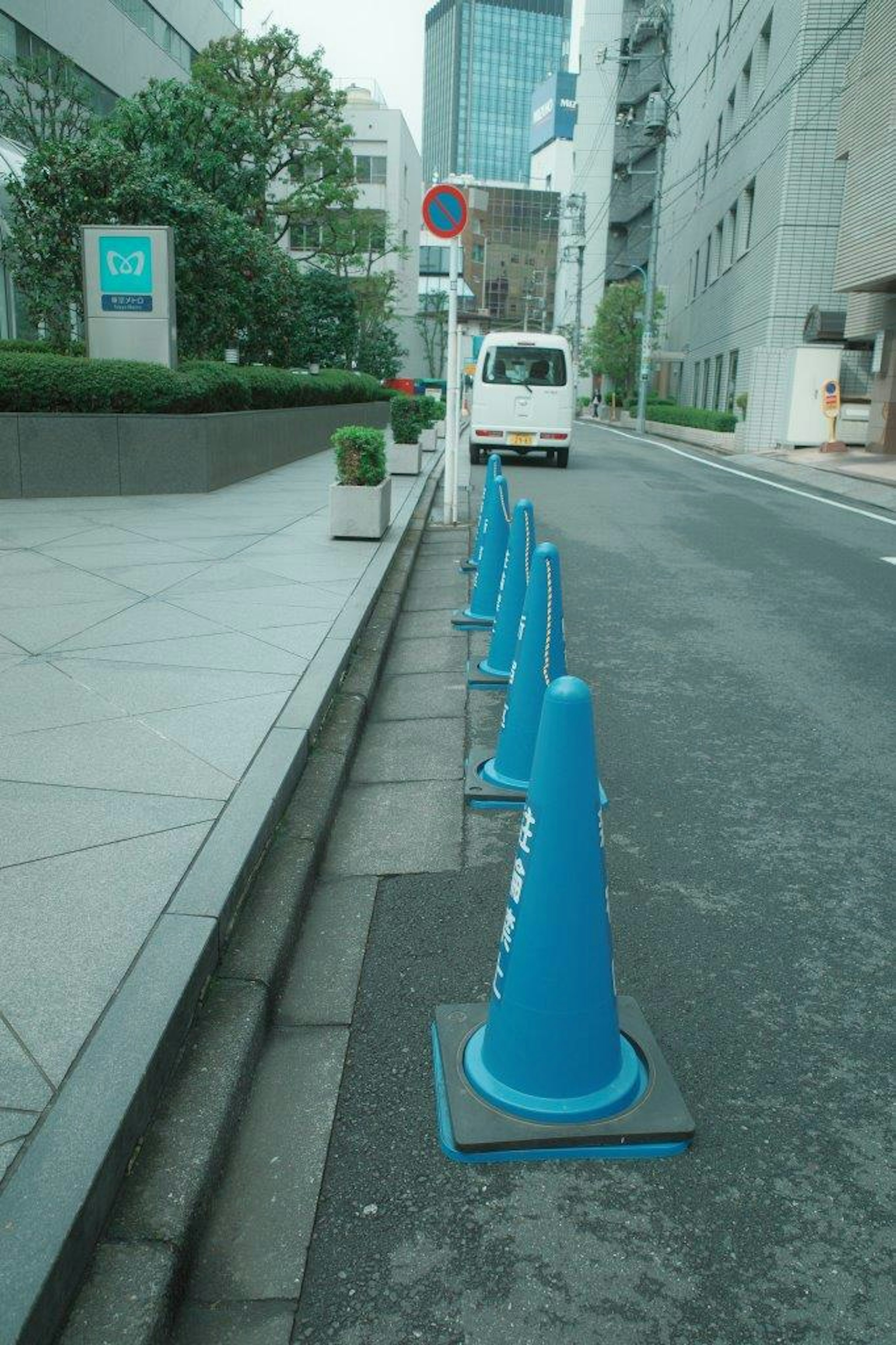 Vista de una calle urbana con conos azules alineados