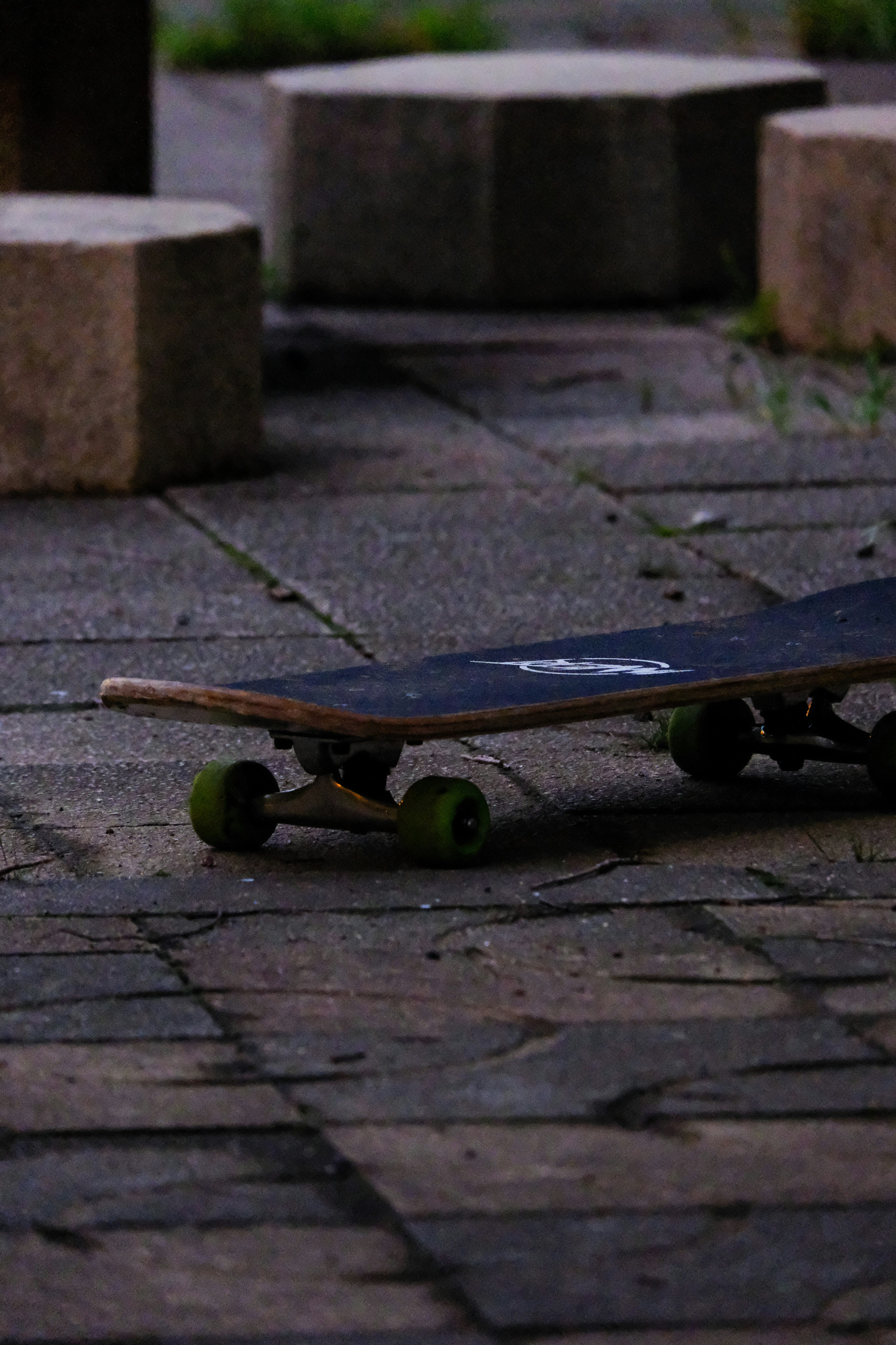 Close-up shot of a skateboard resting on a stone pavement