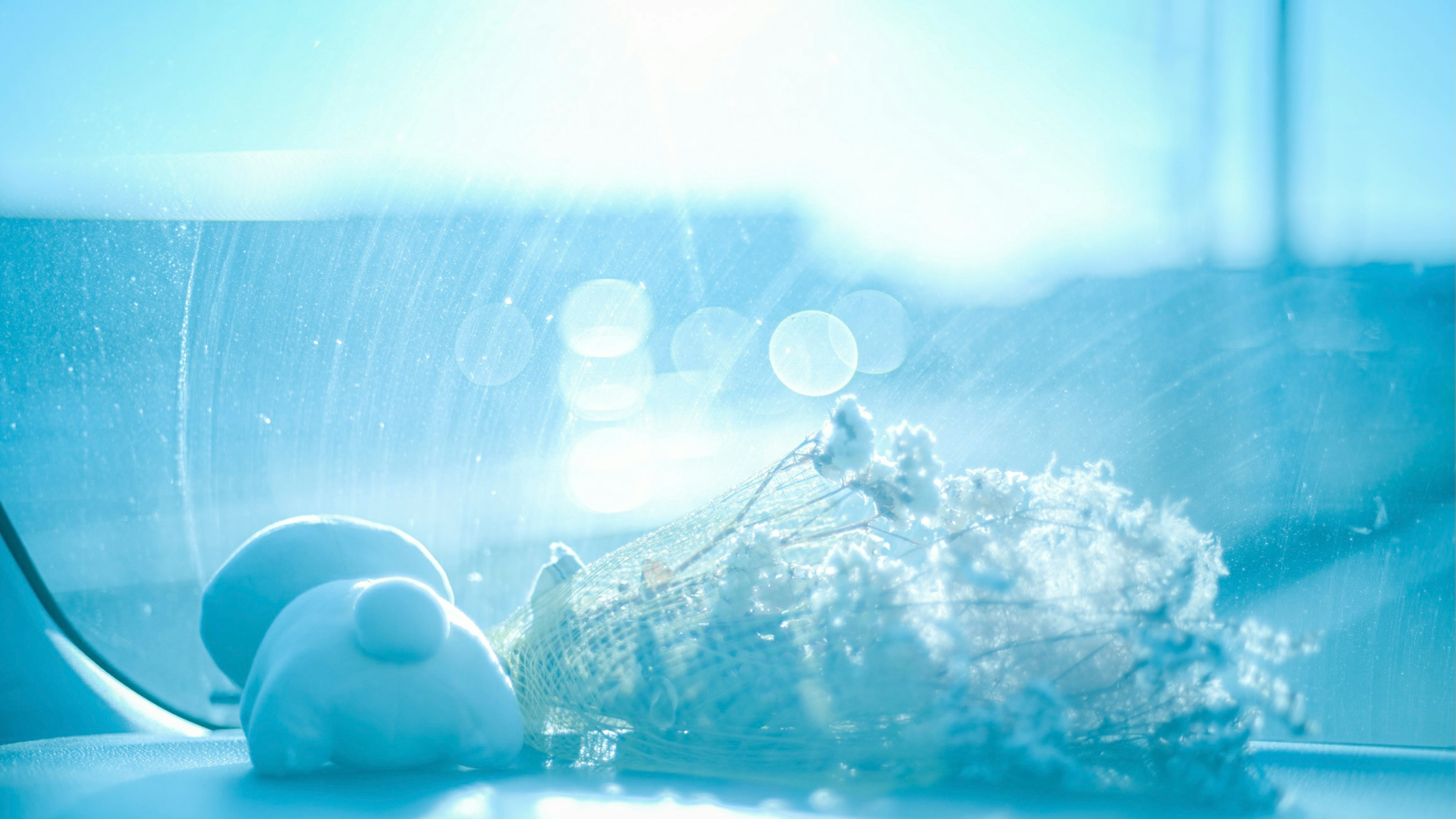 White figurine and flower against a bright blue background