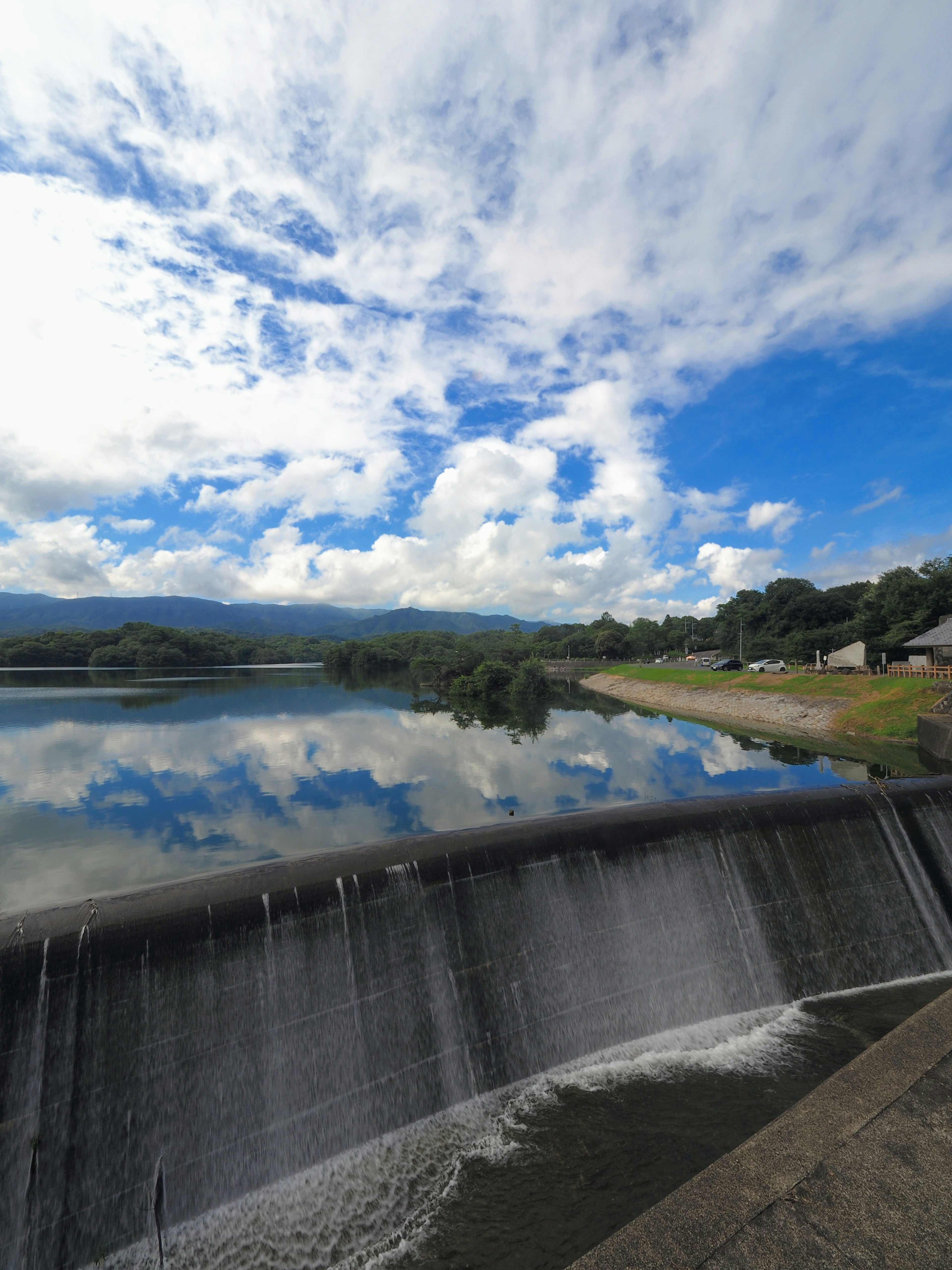 Pemandangan indah bendungan dengan refleksi di air dan langit biru