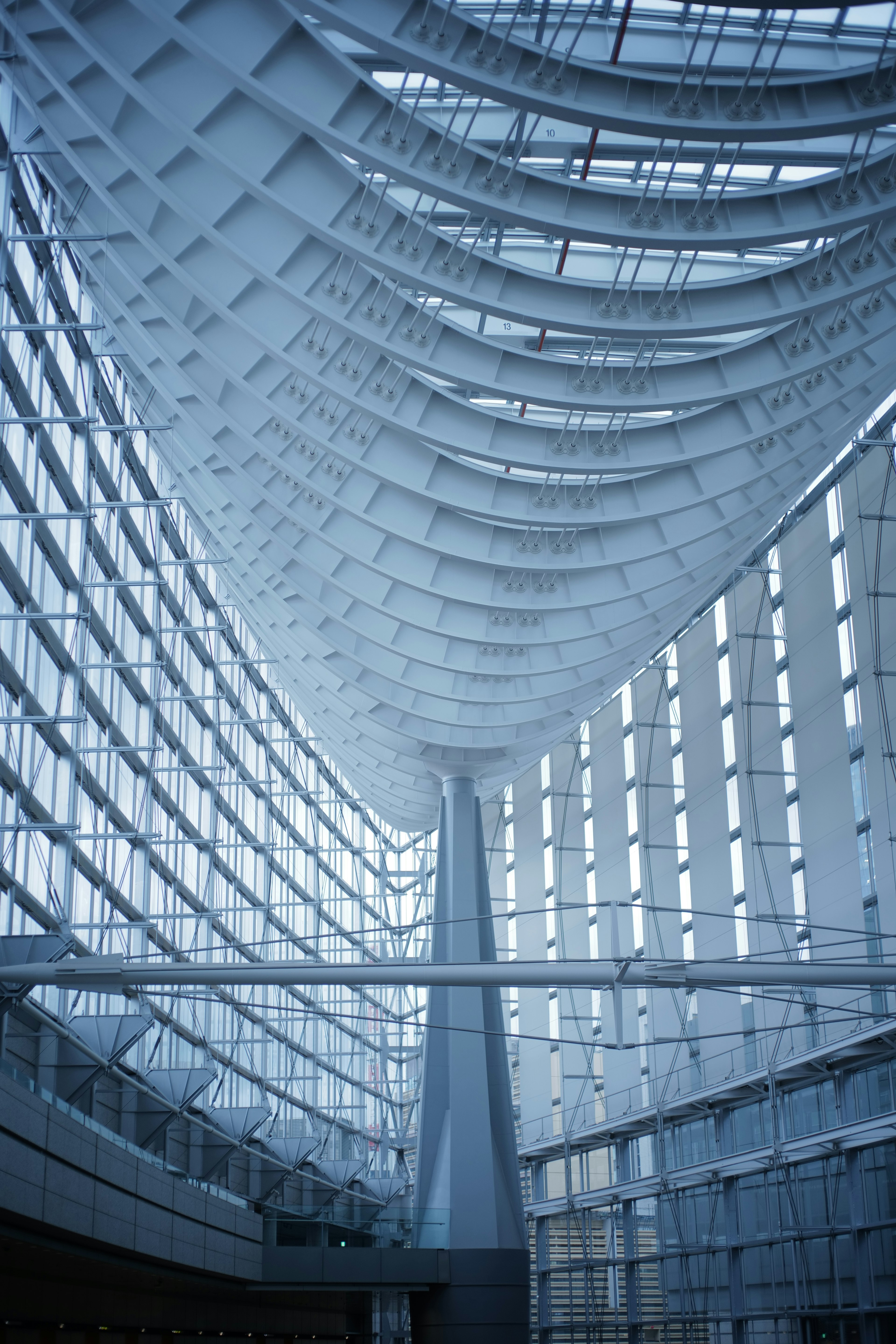 Interior of a modern building featuring large glass walls and a curved ceiling