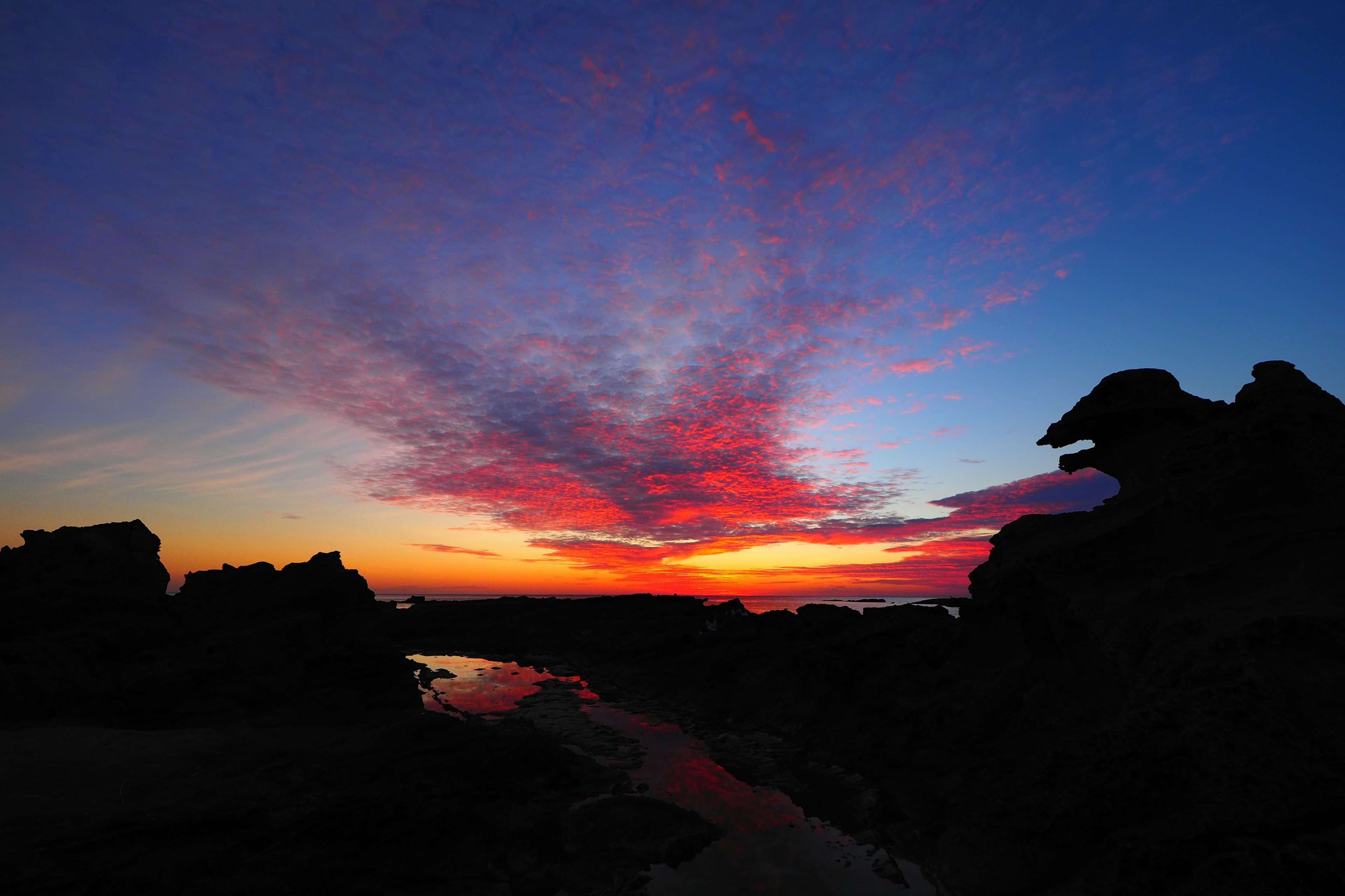 夕焼けが美しい海岸の風景岩のシルエットが際立つ