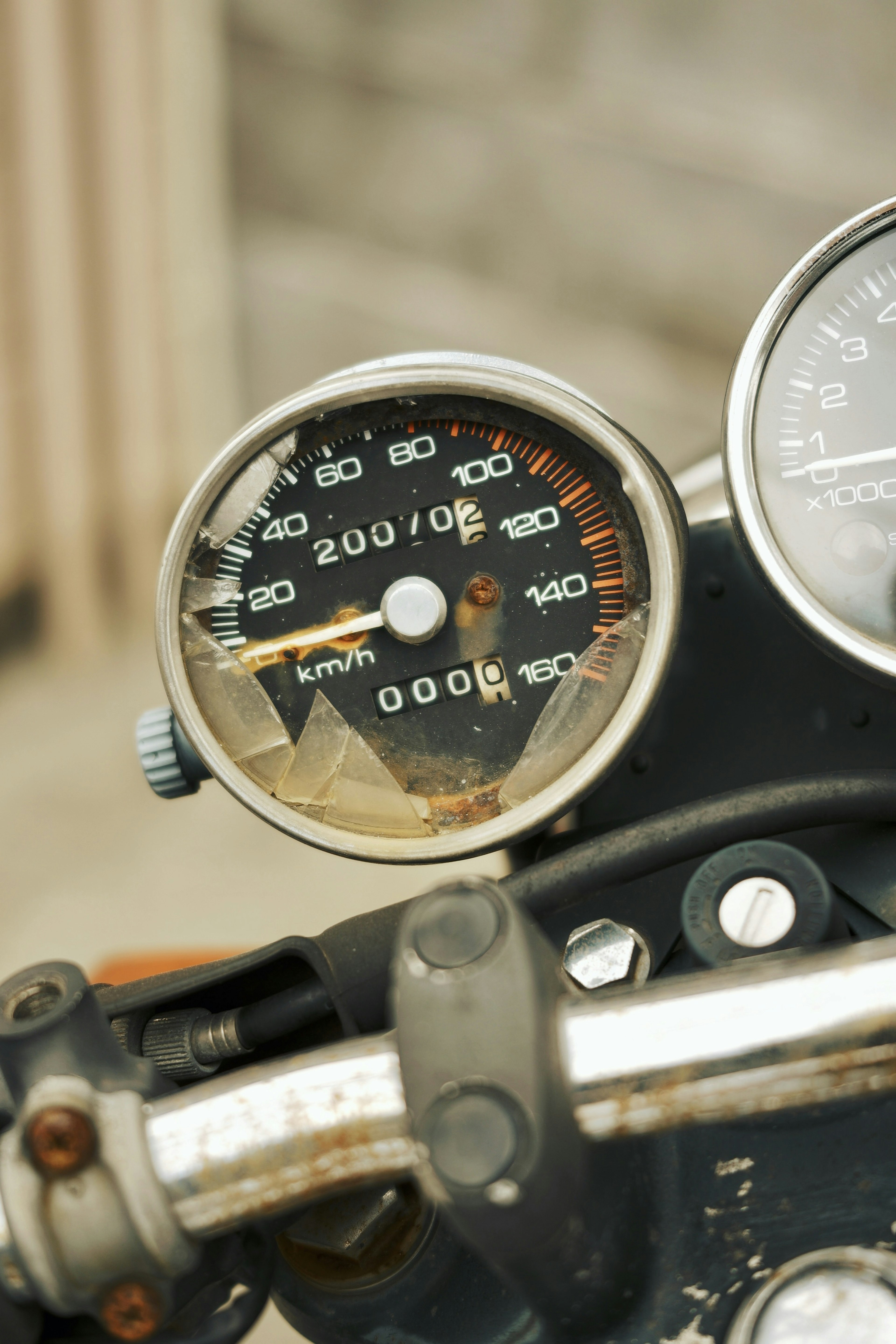 Close-up of a motorcycle speedometer and handlebars showing speed and distance readings