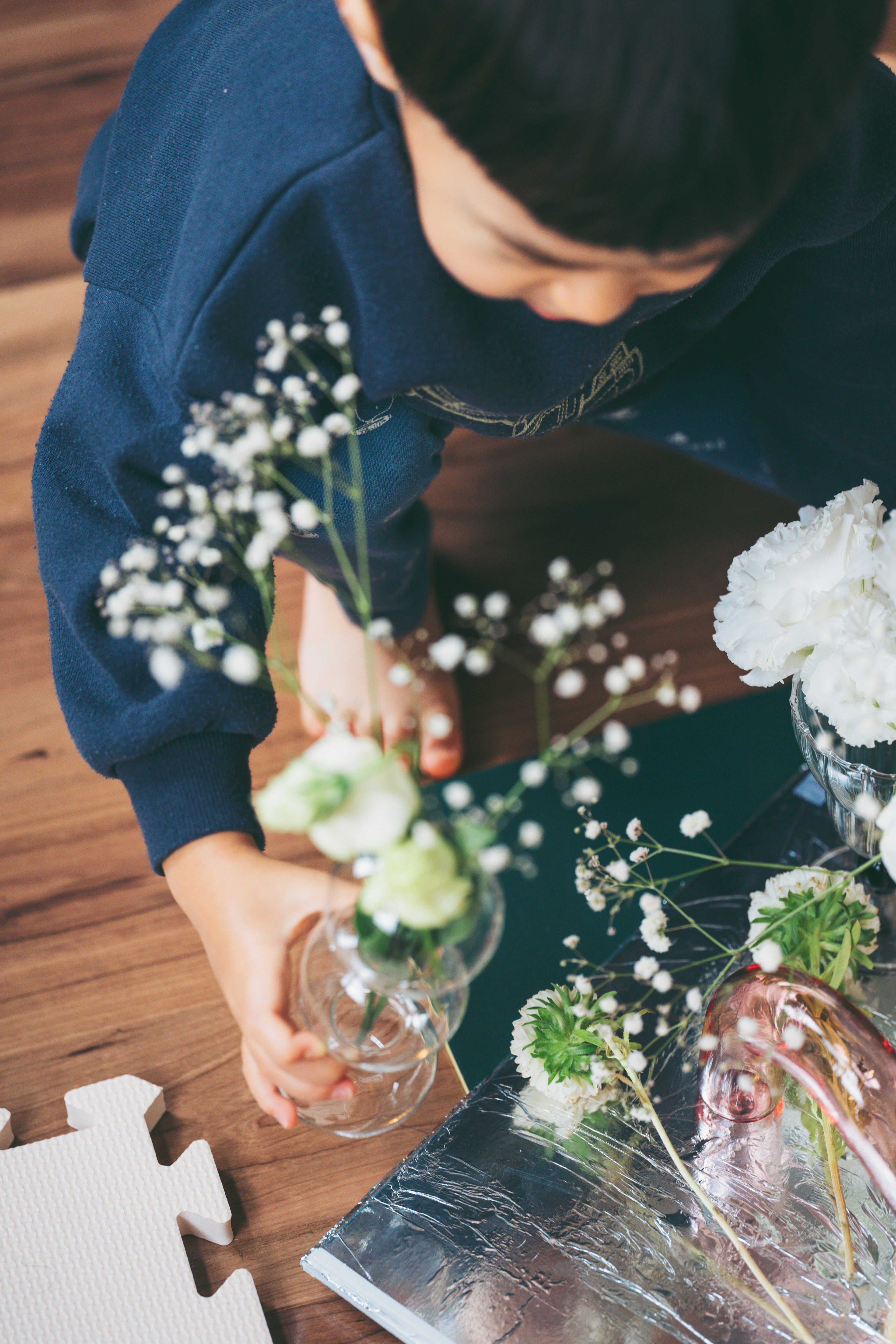 Child arranging flowers in a glass vase