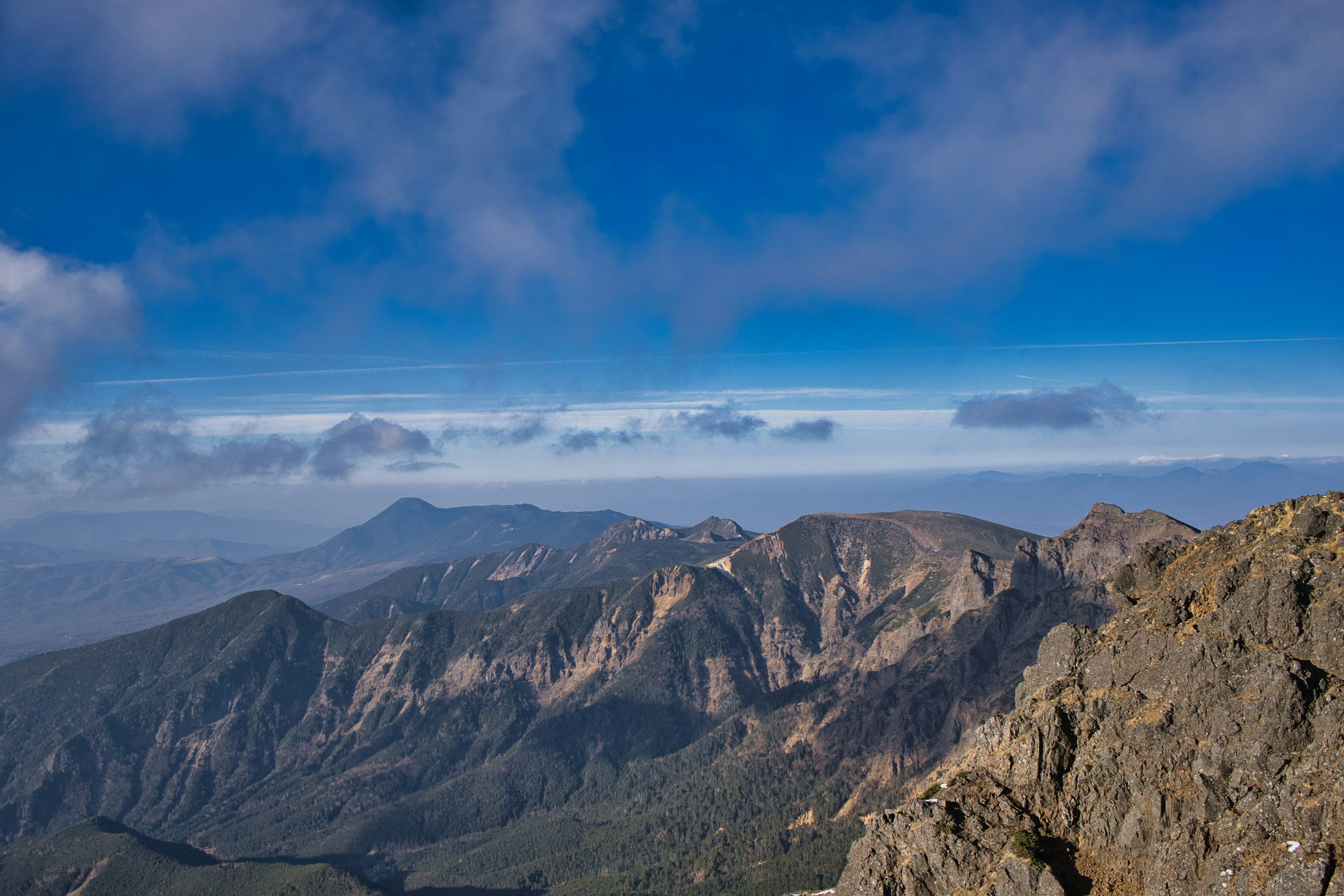 蓝天和云下的山脉风景 背景中远处的山峰