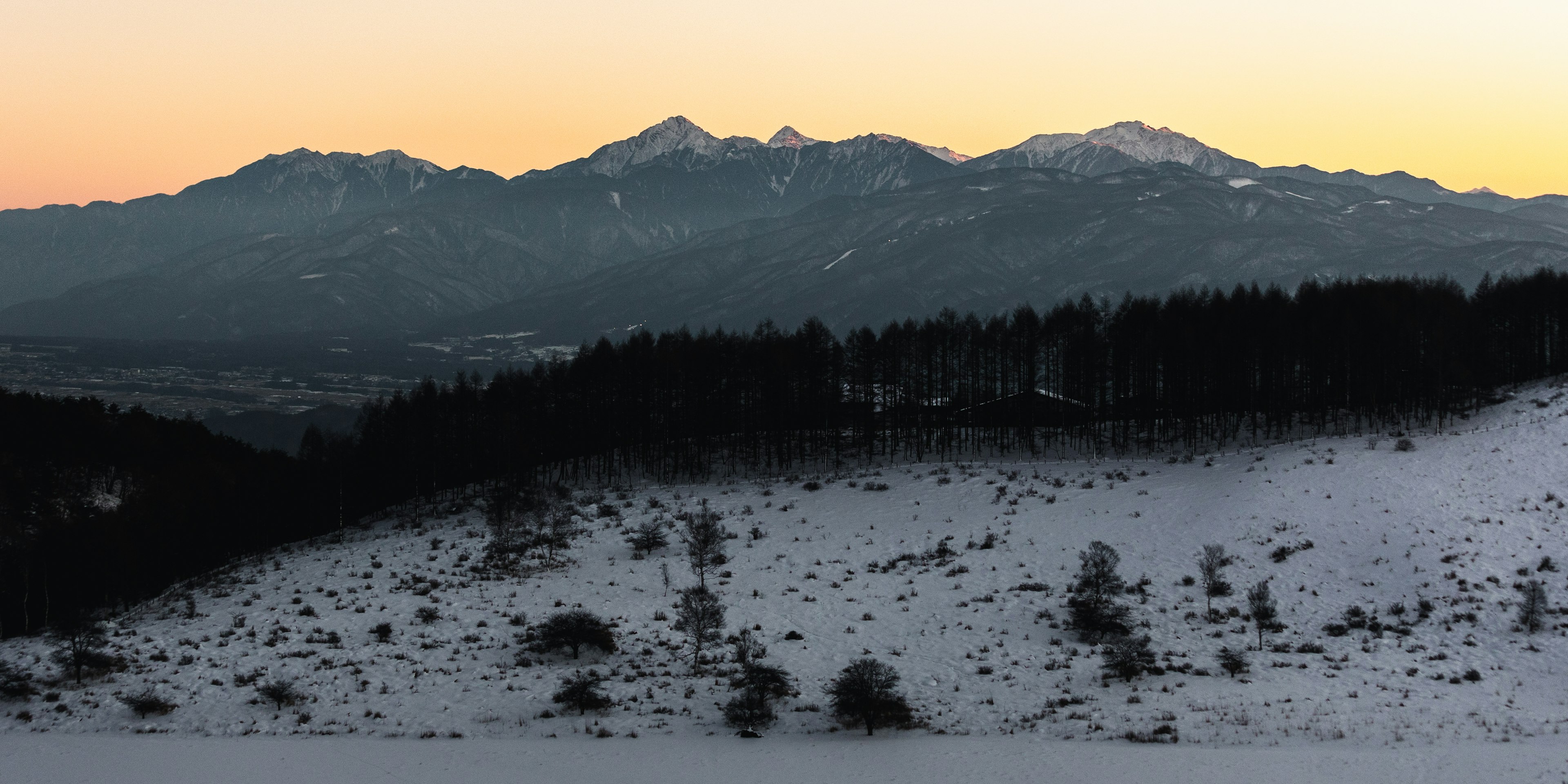 雪に覆われた山々と夕焼けの空の風景