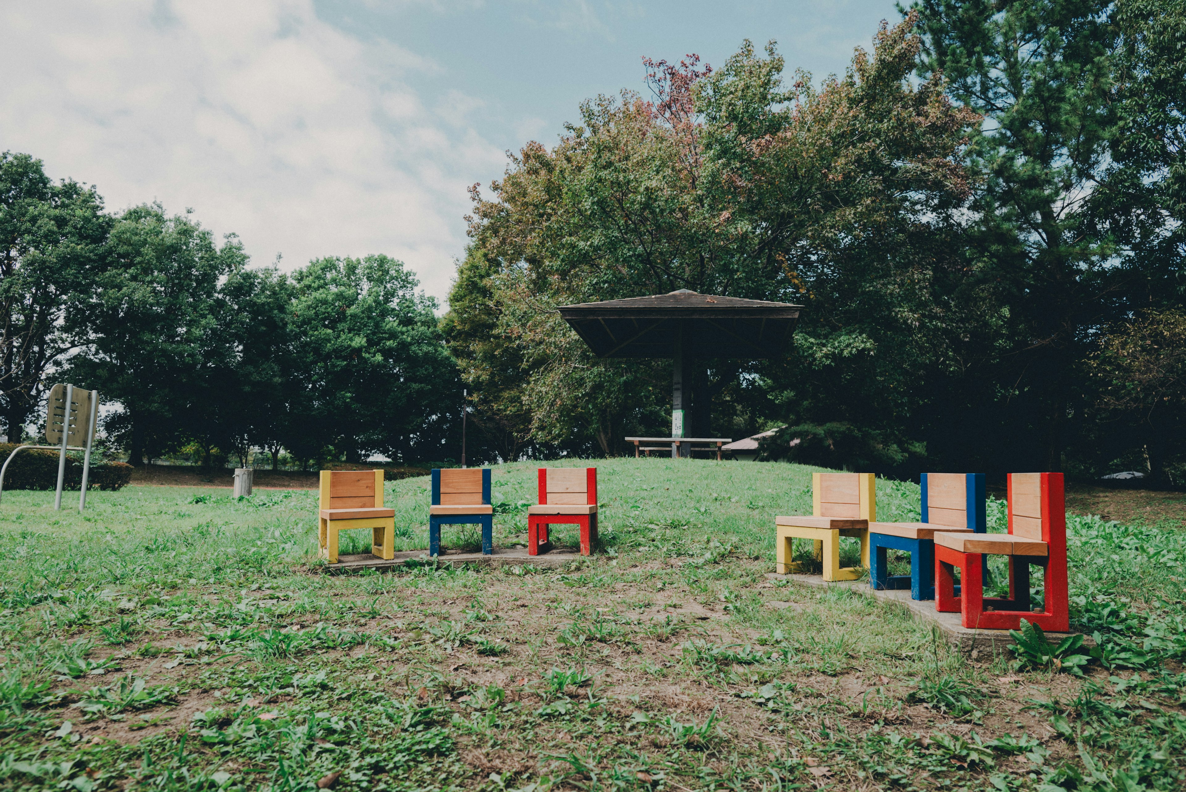 Bunte Stühle in einer Parklandschaft angeordnet