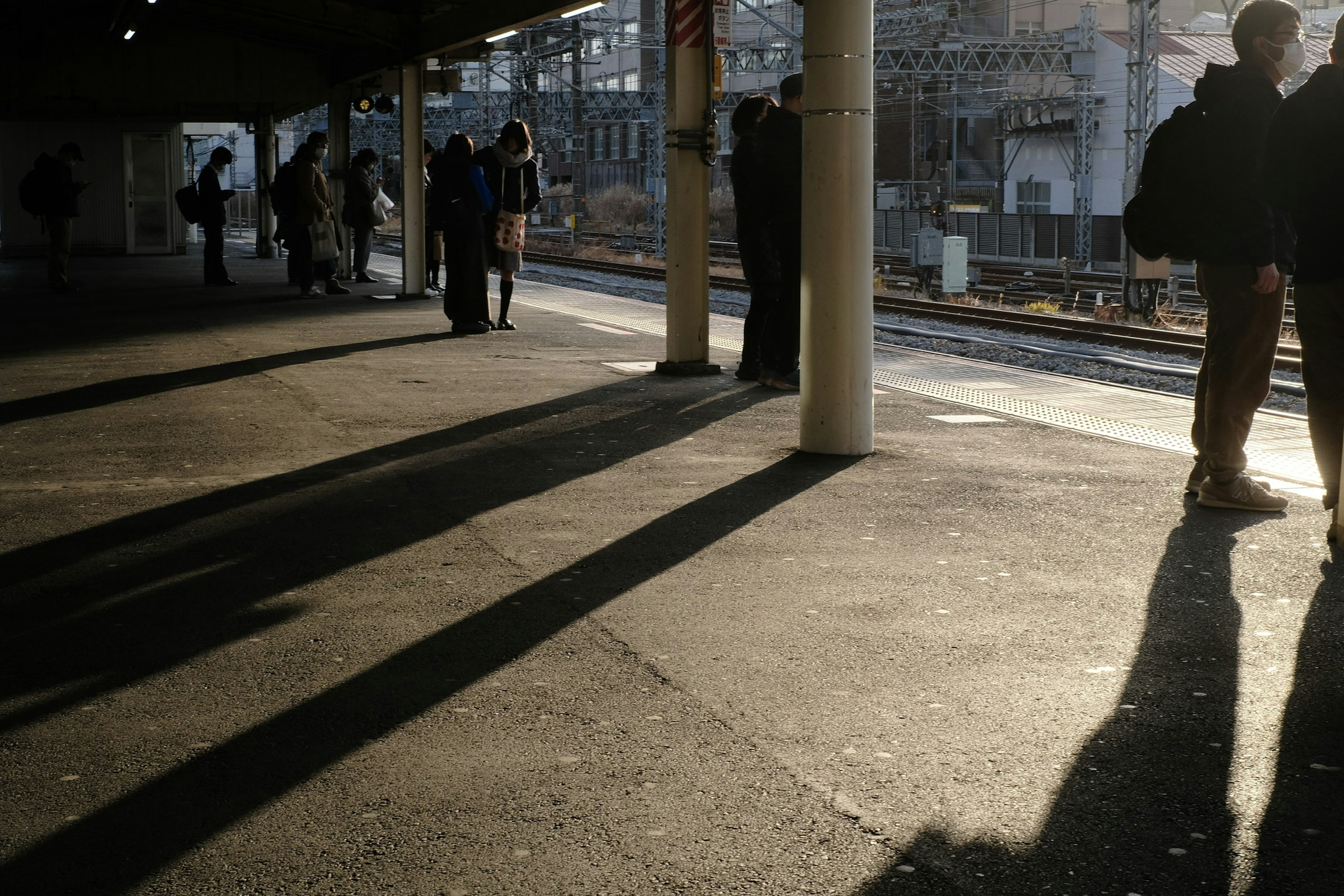 駅のプラットフォームで影が長く伸びる風景