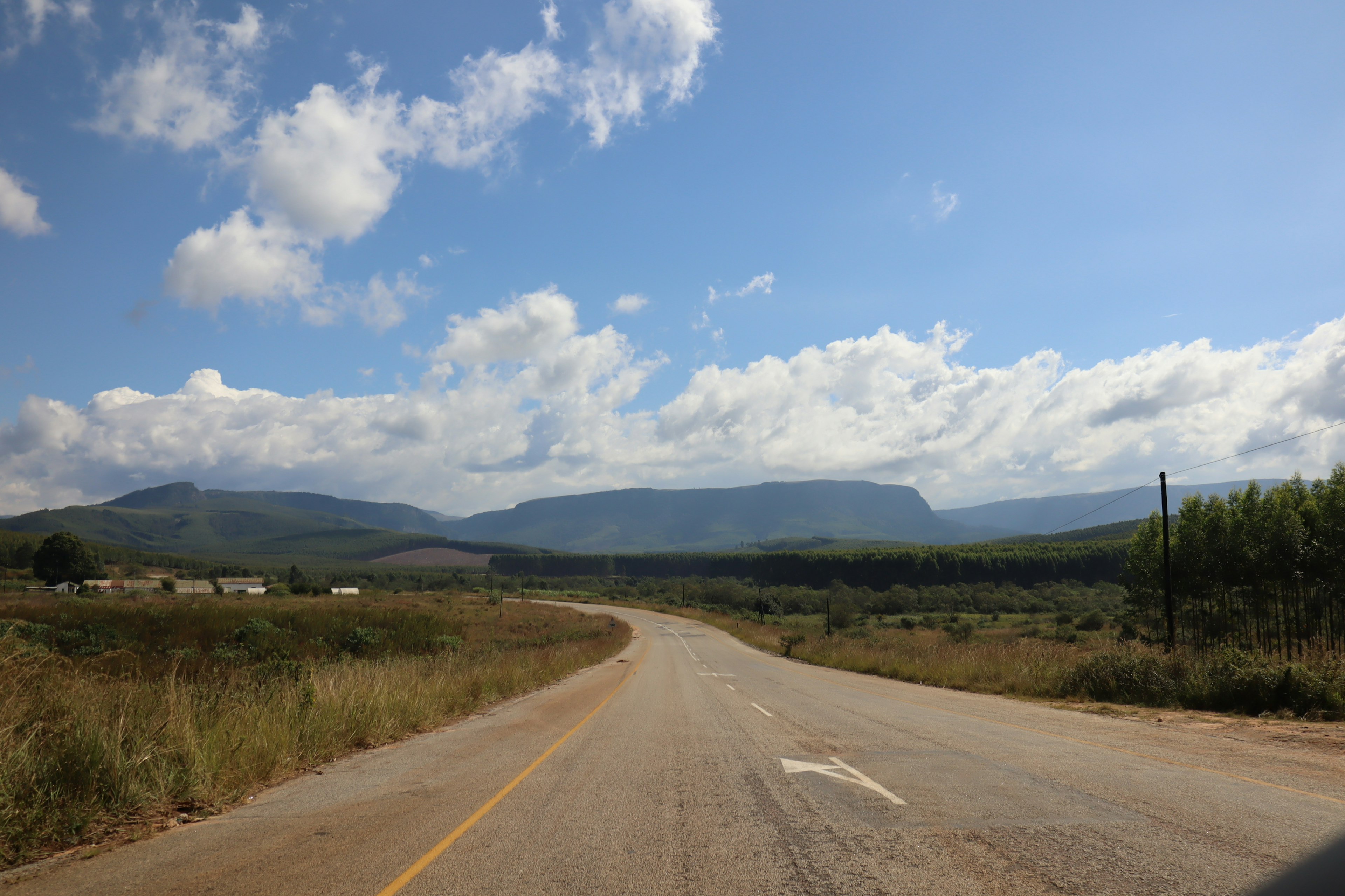 Camino escénico con montañas y cielo azul