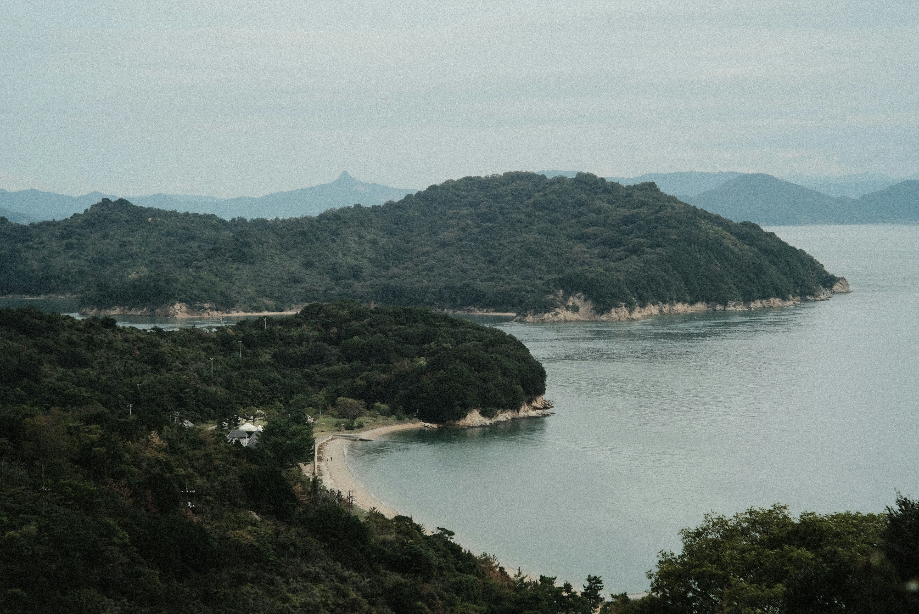 穏やかな海岸線と緑の丘が広がる風景