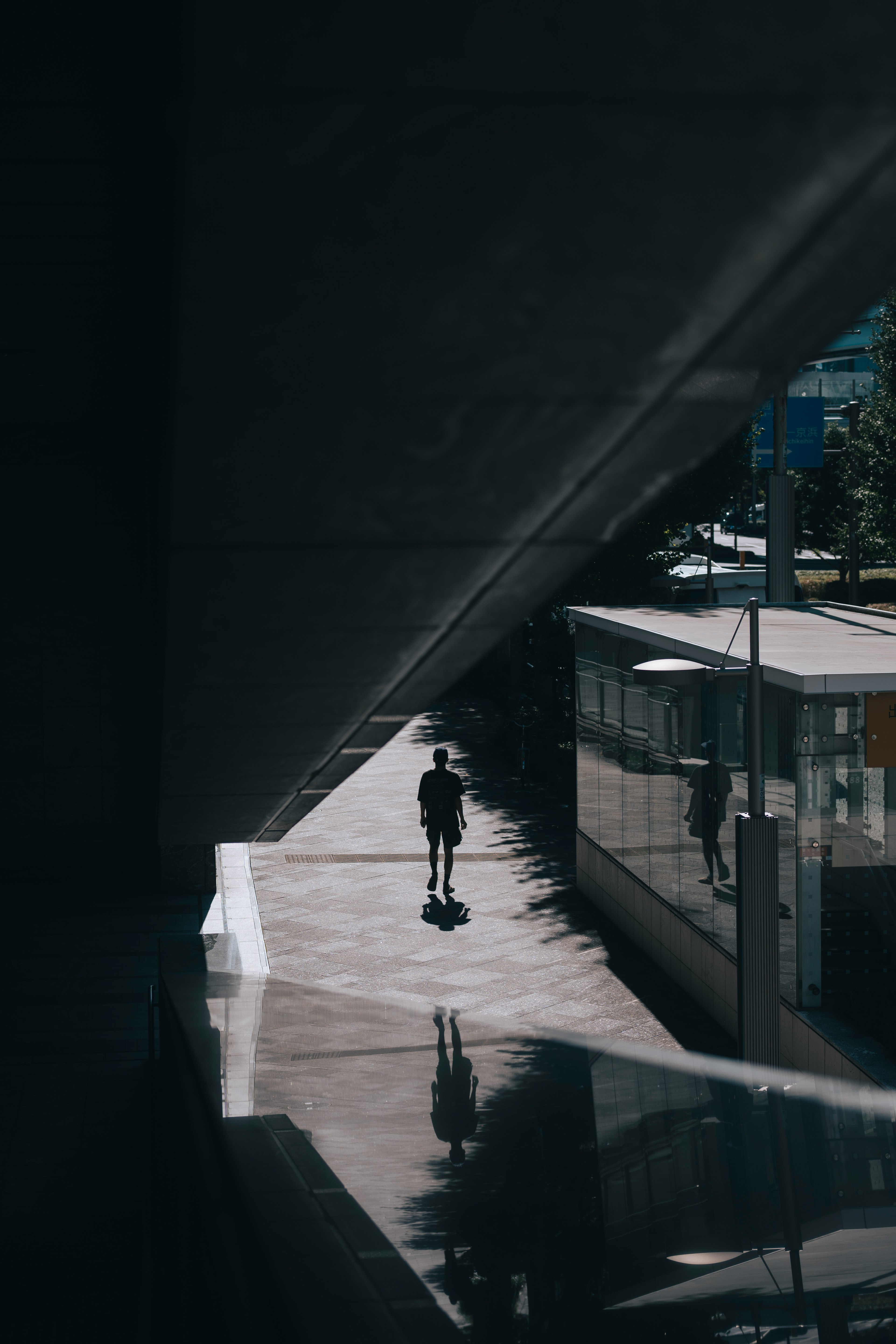 Silhouette di una persona che cammina nell'ombra con uno scenario urbano