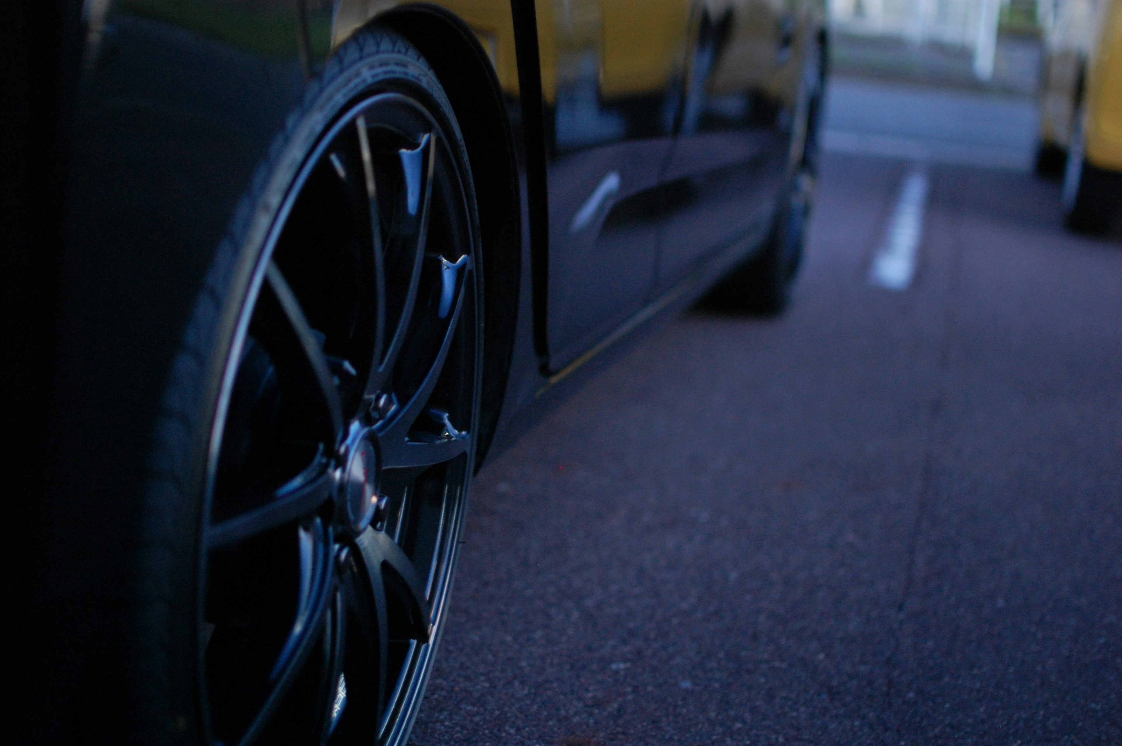 Close-up of a black car wheel and pavement