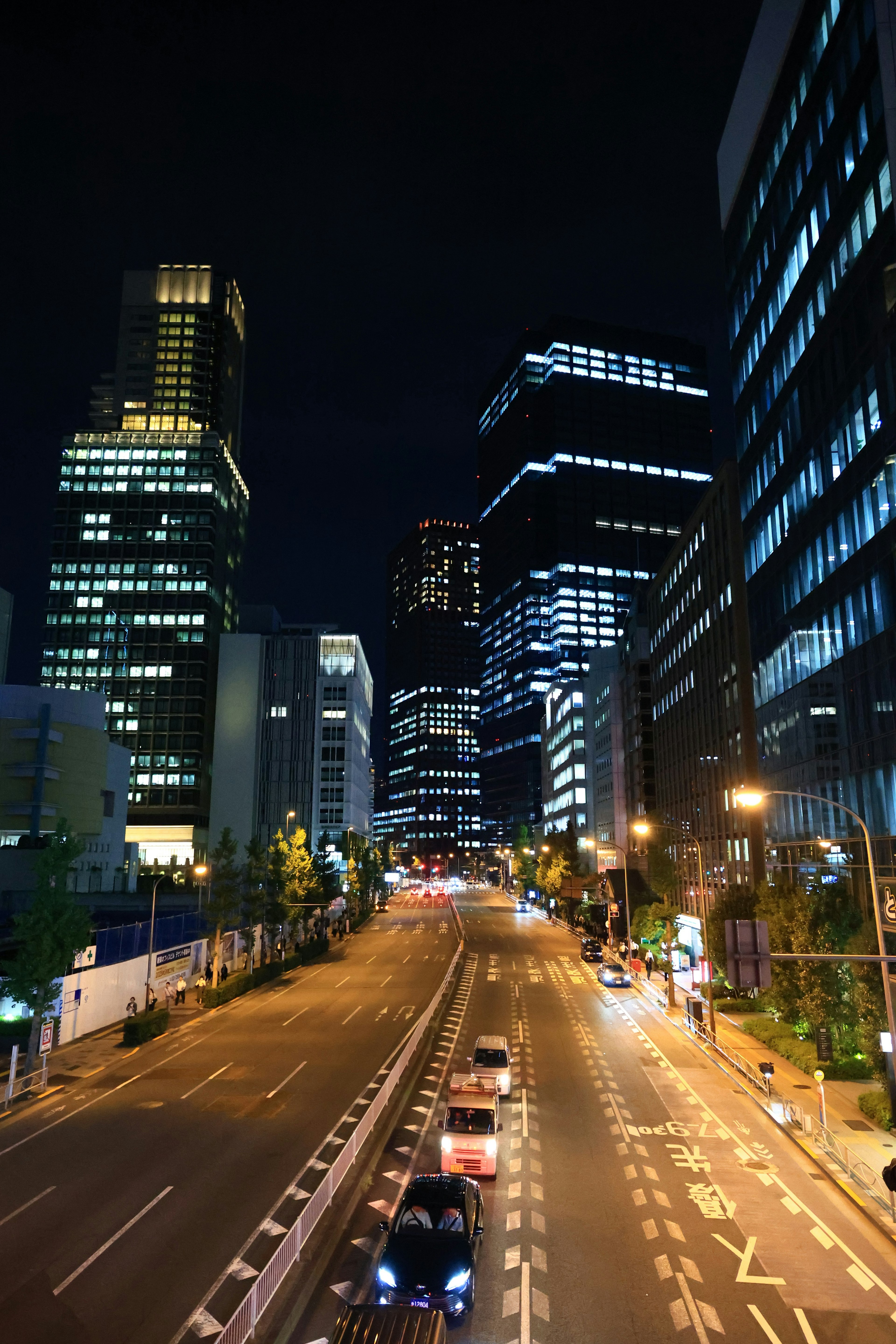 Night cityscape featuring tall buildings and a busy road