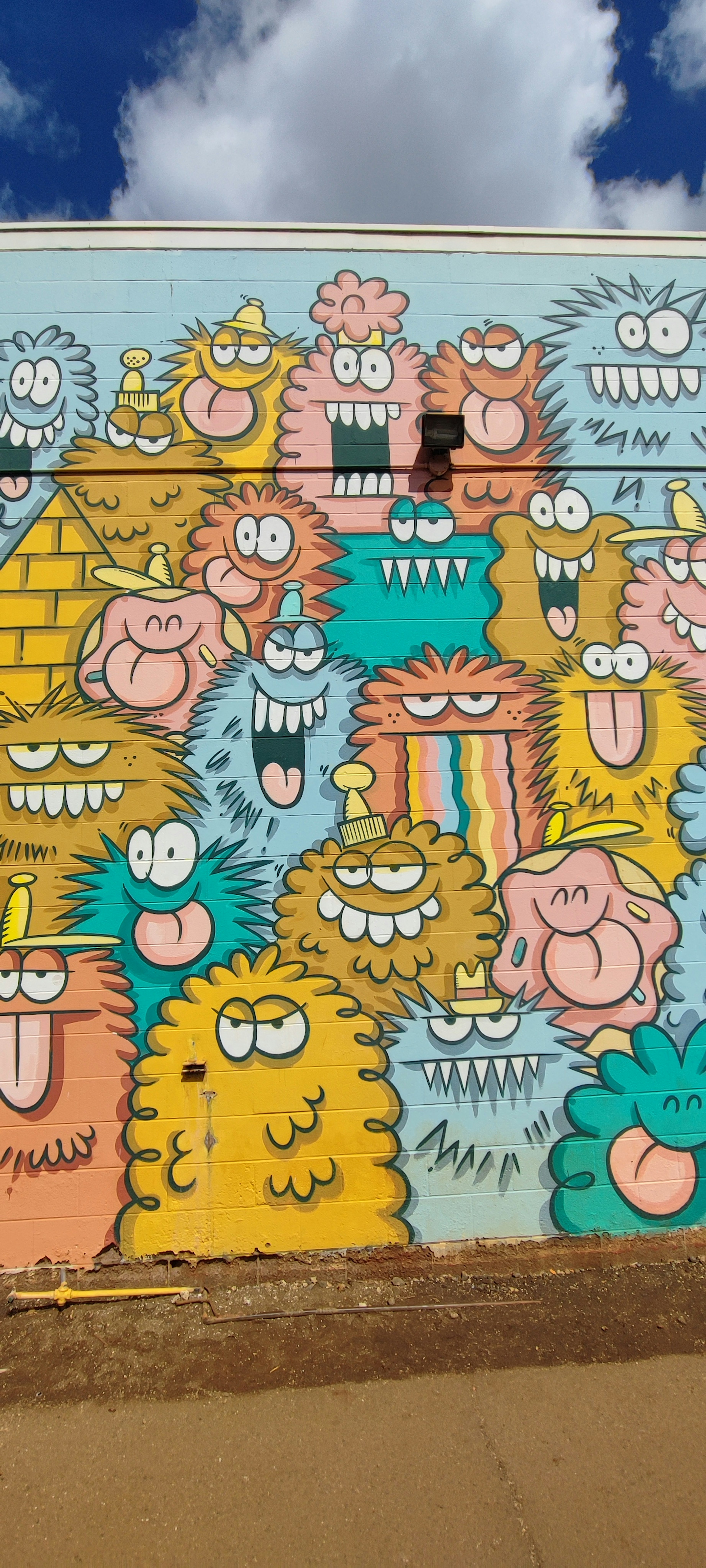 Bunter Monster-Mural an einer Wand mit verschiedenen cartoonhaften Charakteren