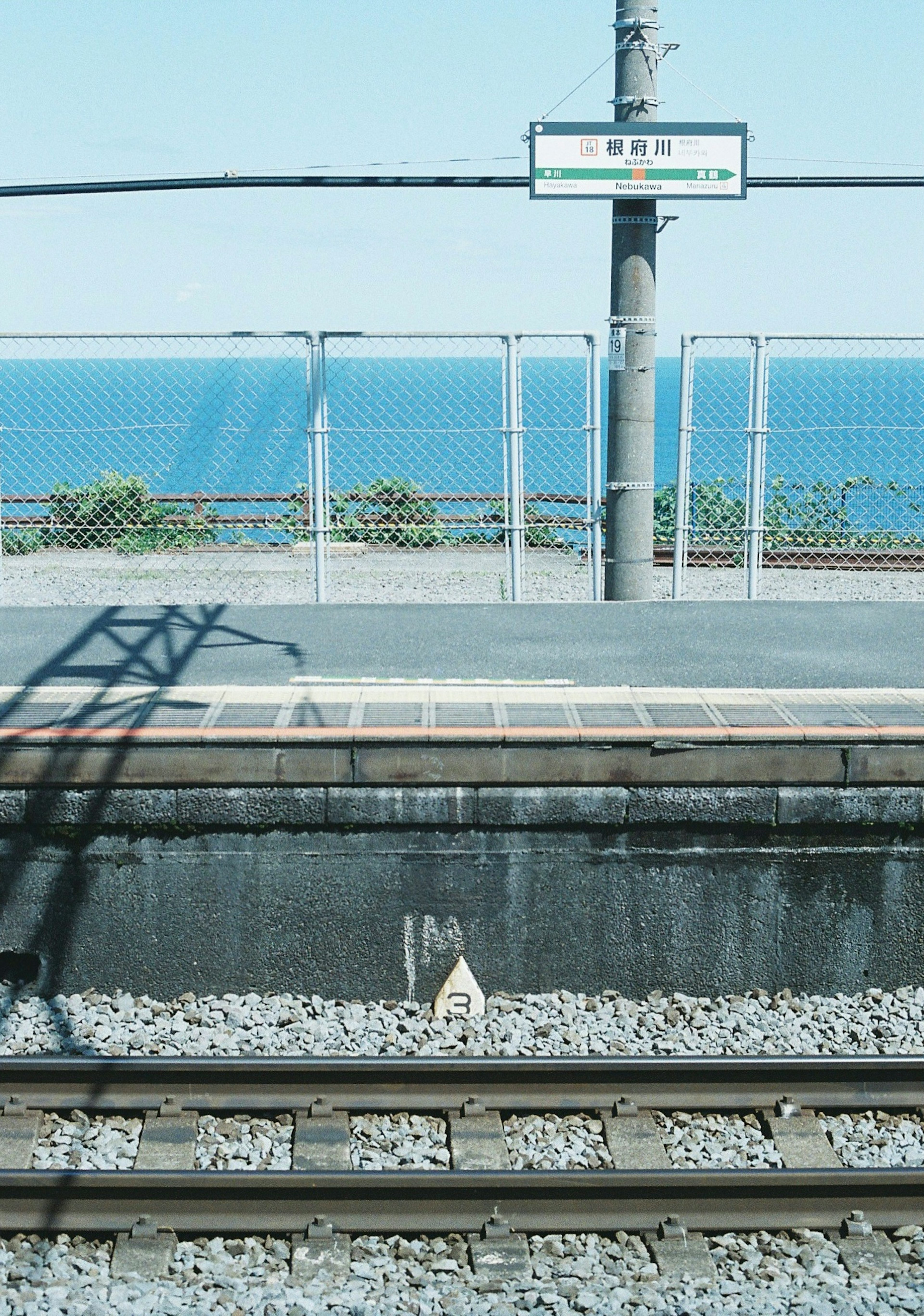 海が見える駅のプラットフォームと線路