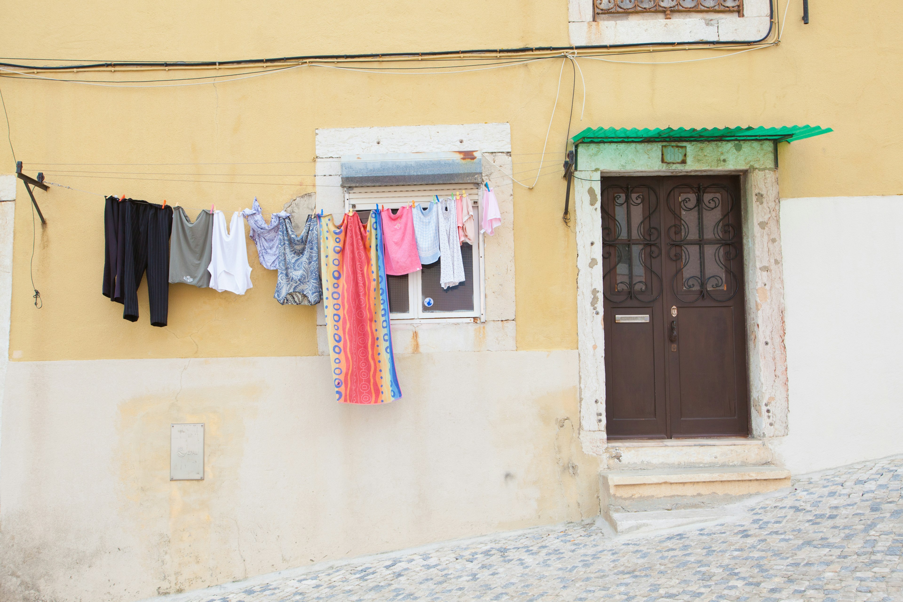 Vestiti appesi a una finestra su una casa gialla