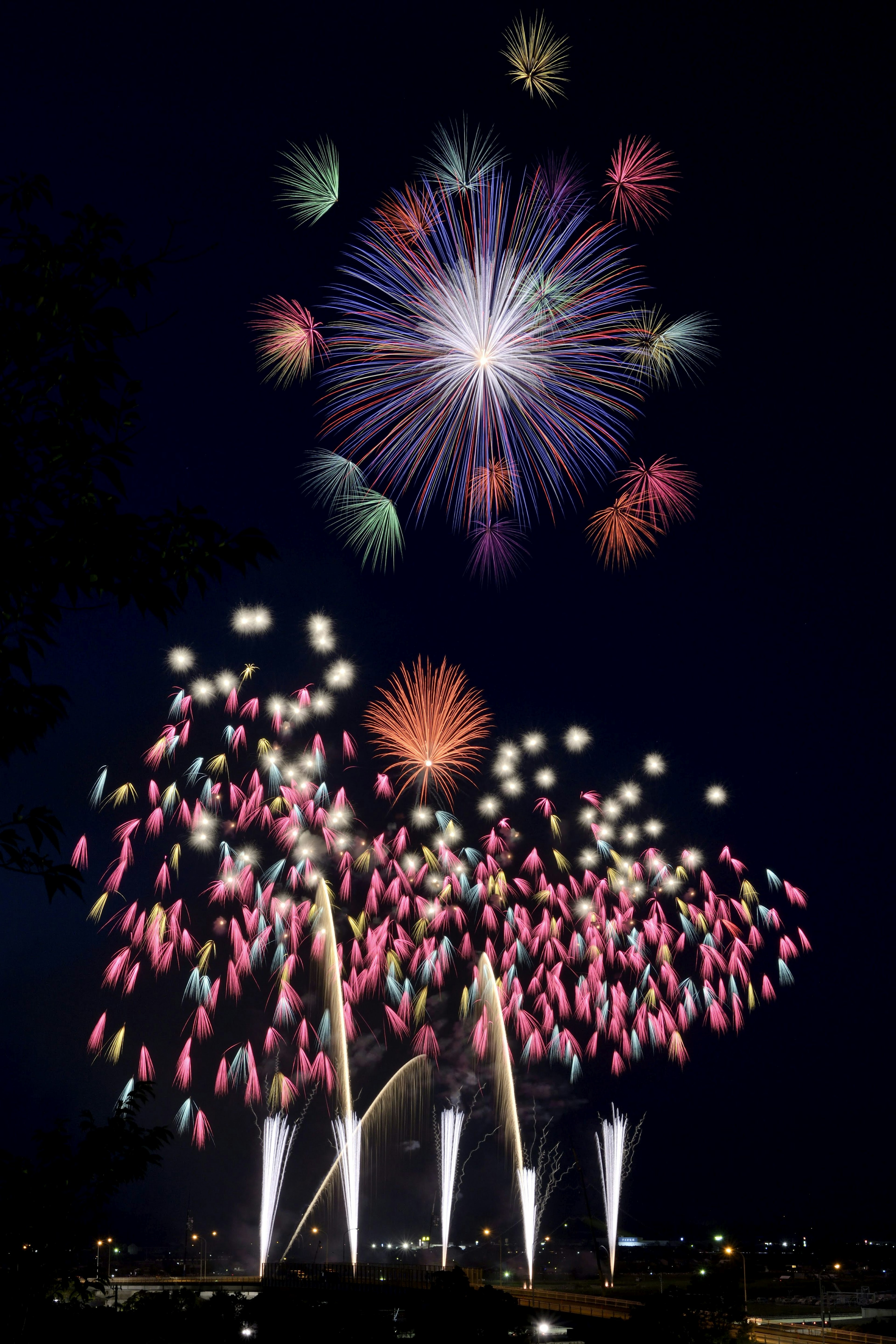 Colorful fireworks exploding in the night sky with fountains