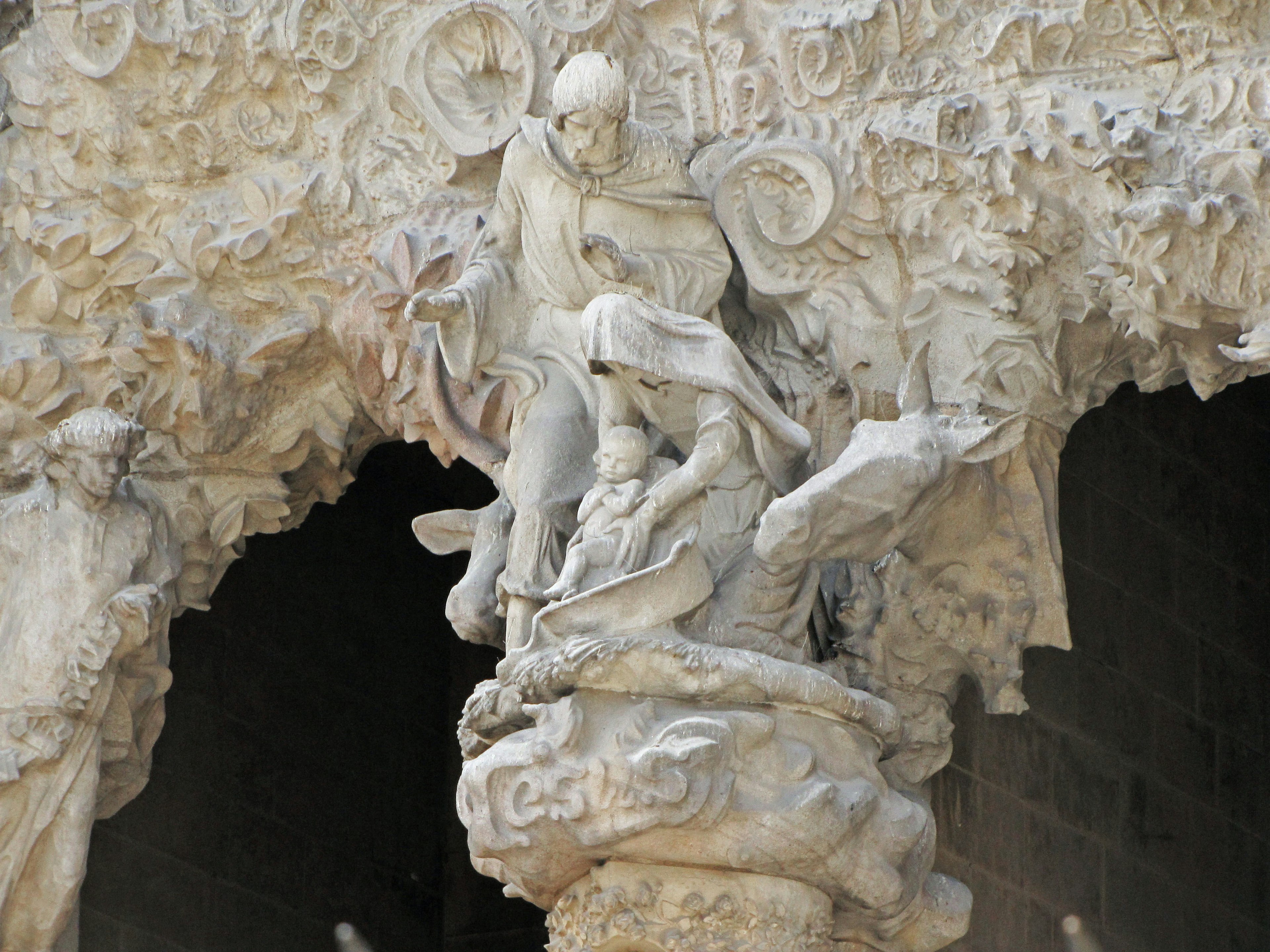 Sculpture détaillée de figures mythologiques assises sur une colonne en pierre sculptée