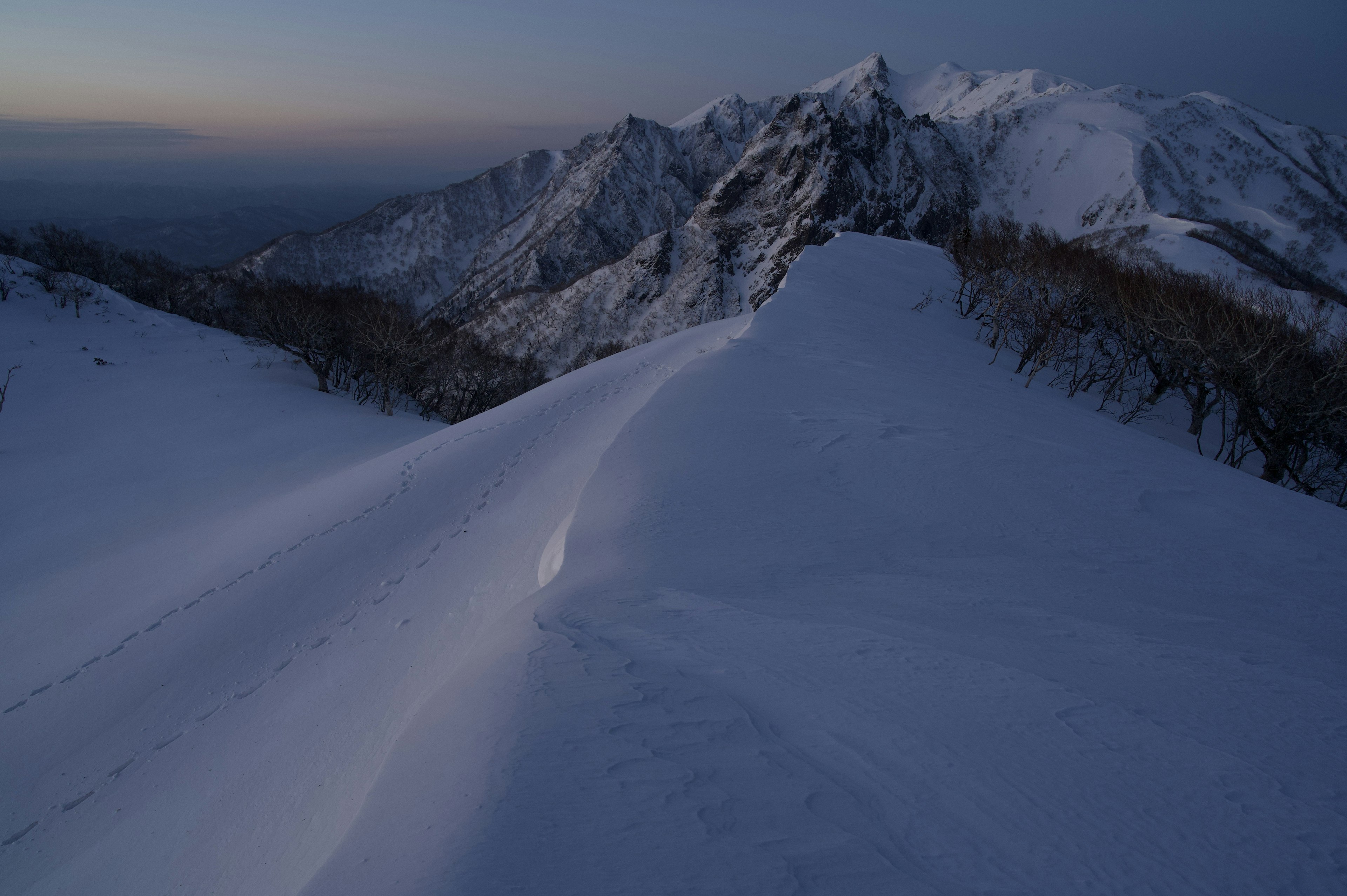 Paysage de montagne enneigée au crépuscule avec des teintes bleues