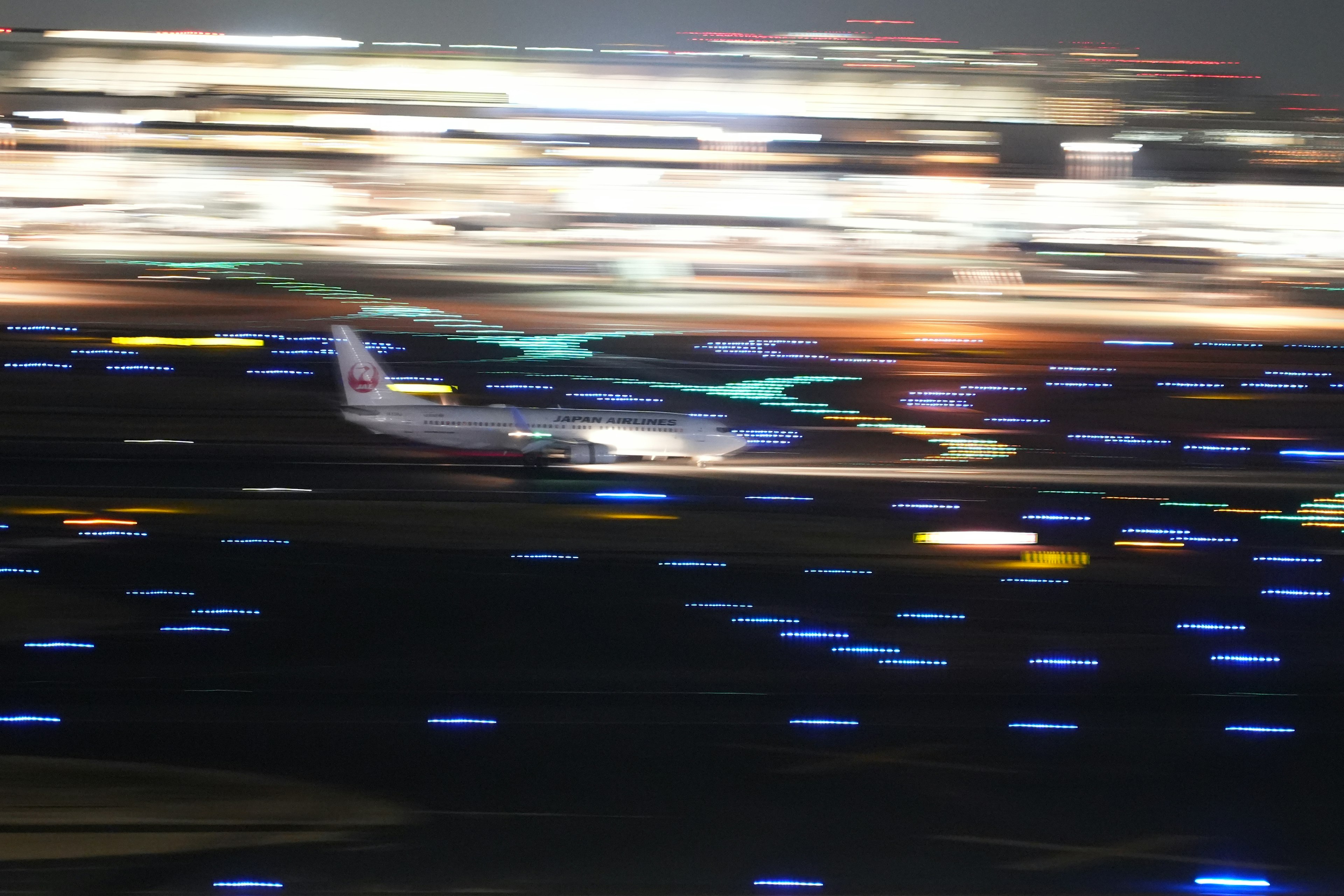 Airplane landing at night with illuminated runway lights