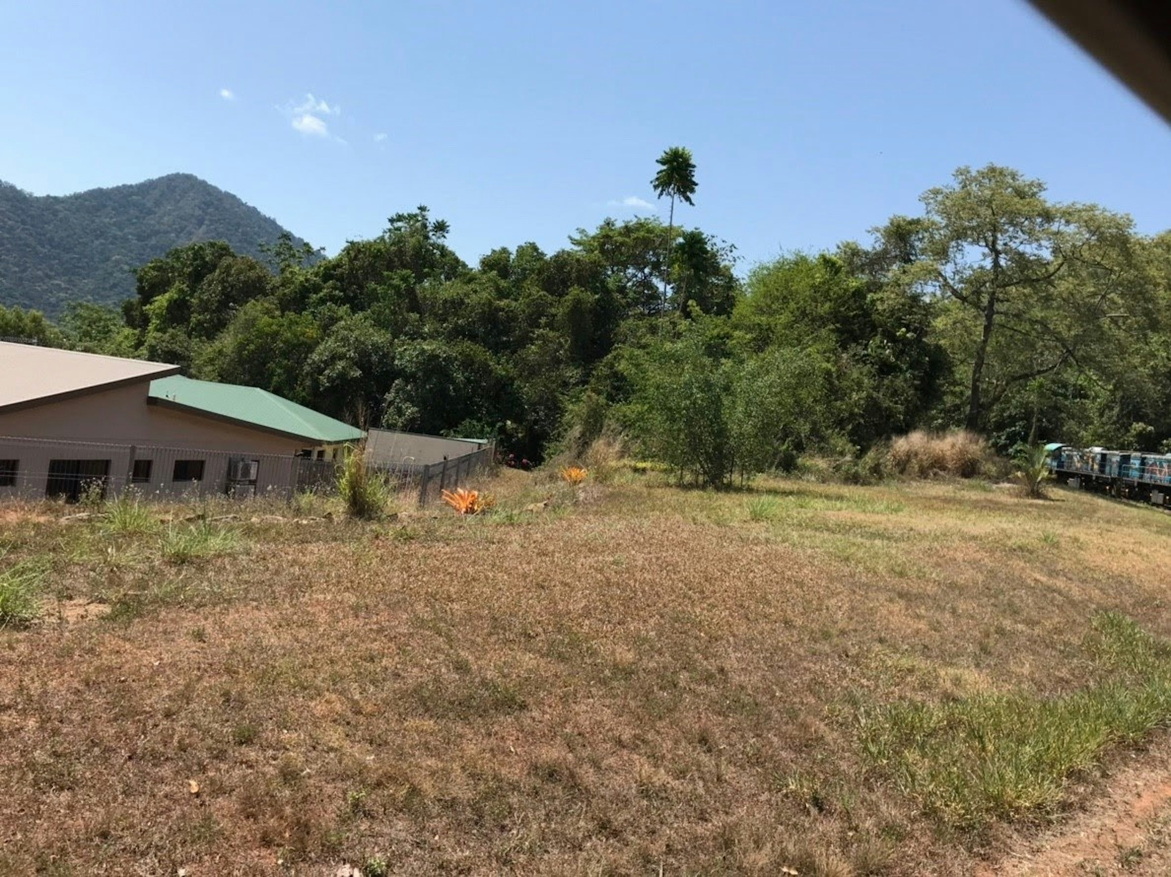 Paysage avec un champ vide entouré de montagnes et d'un bâtiment