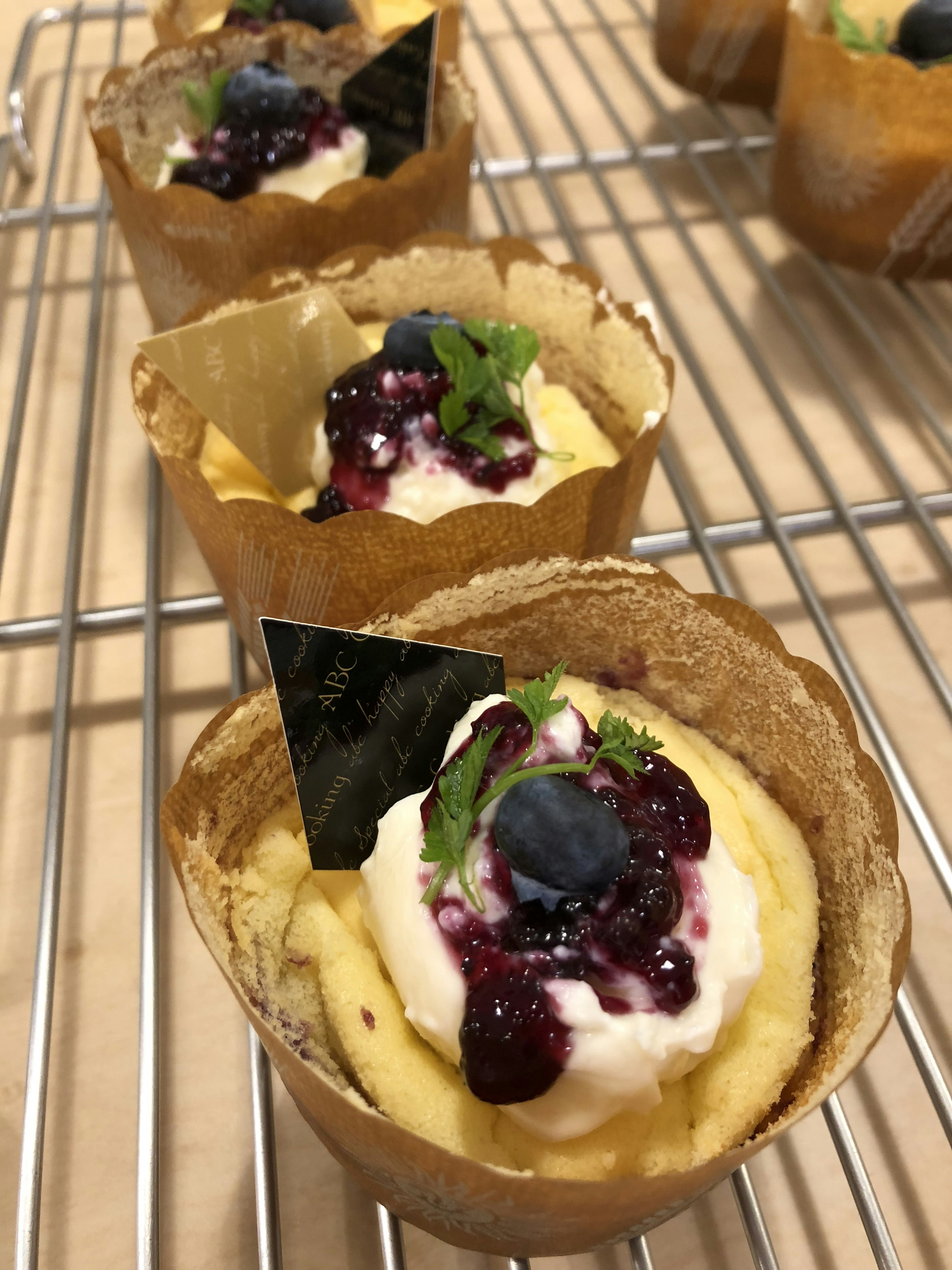 Cupcakes topped with cream and berries in decorative wrappers