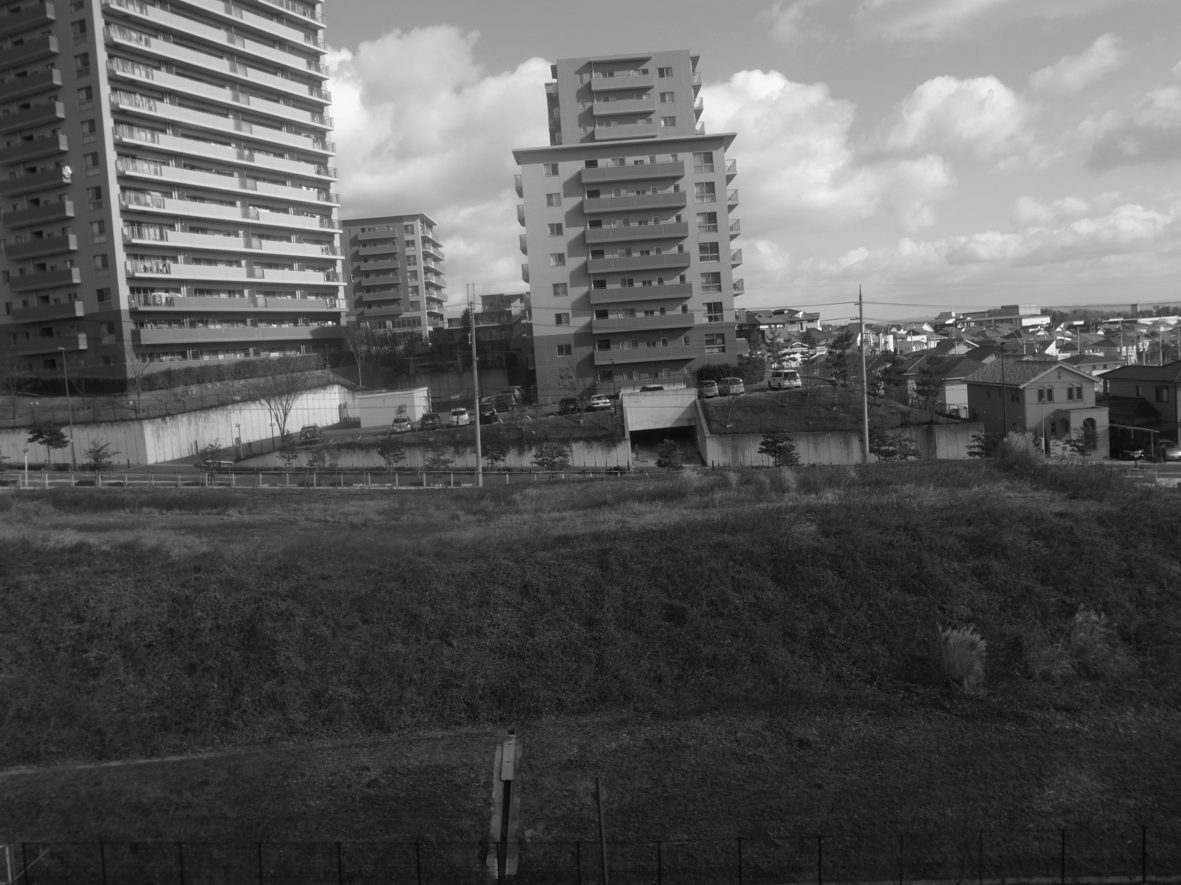 Urban landscape featuring tall buildings and residential areas with blue sky and clouds