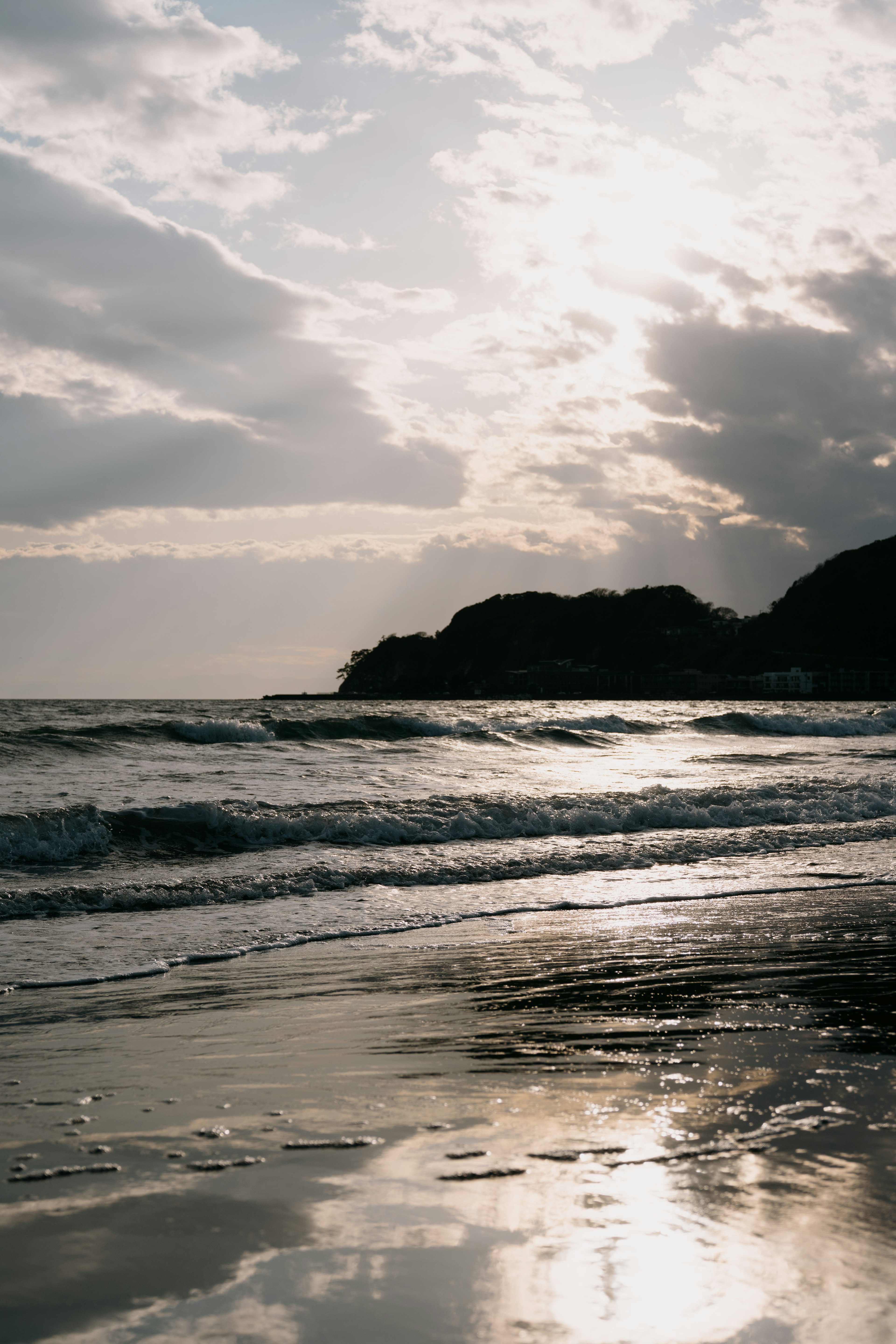 Evening sky reflecting on the coastline with waves and clouds