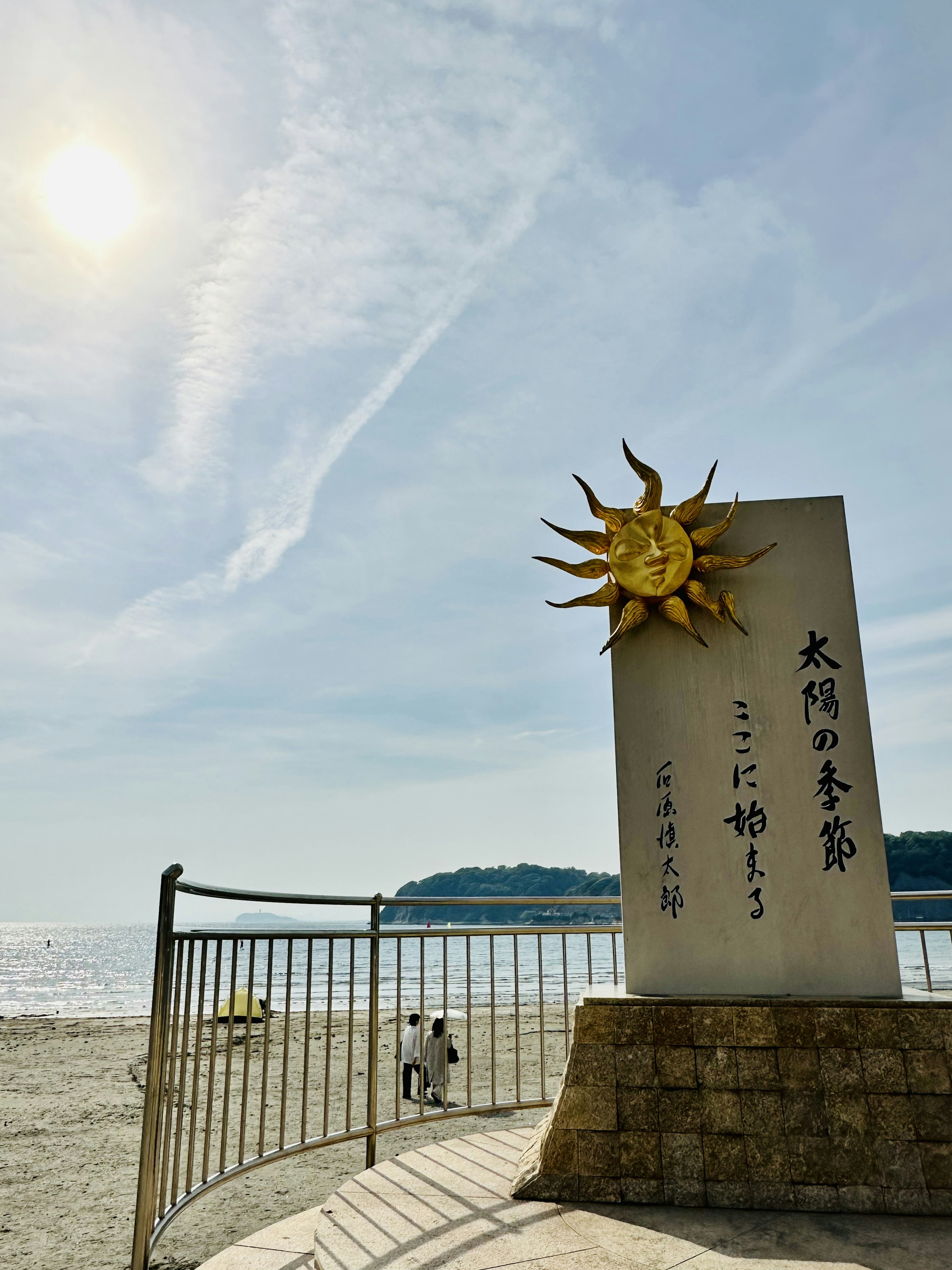 海灘上的太陽雕塑和日文銘文晴朗的天空和寧靜的海景