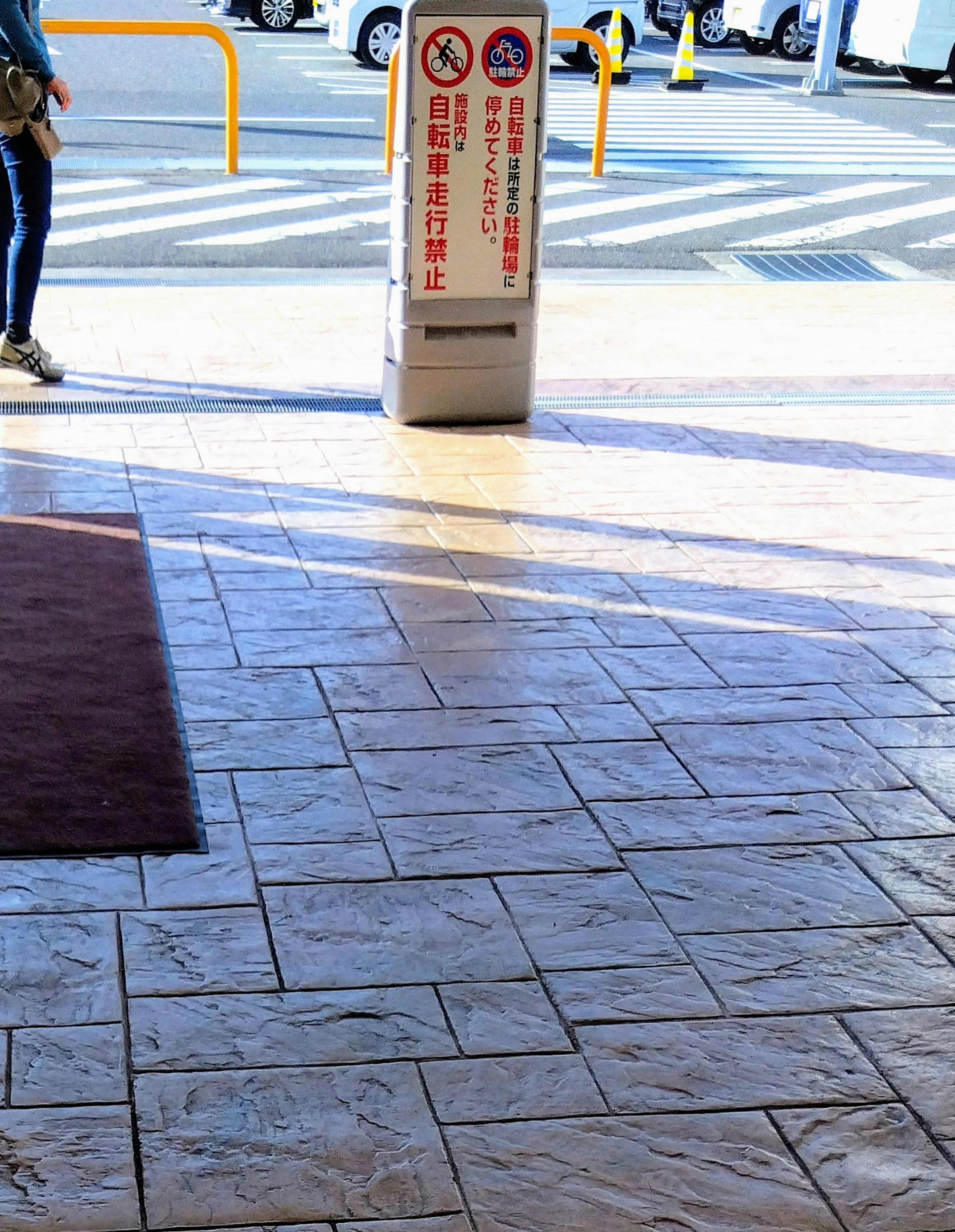 A scene featuring a tiled floor under bright sunlight with a standing sign