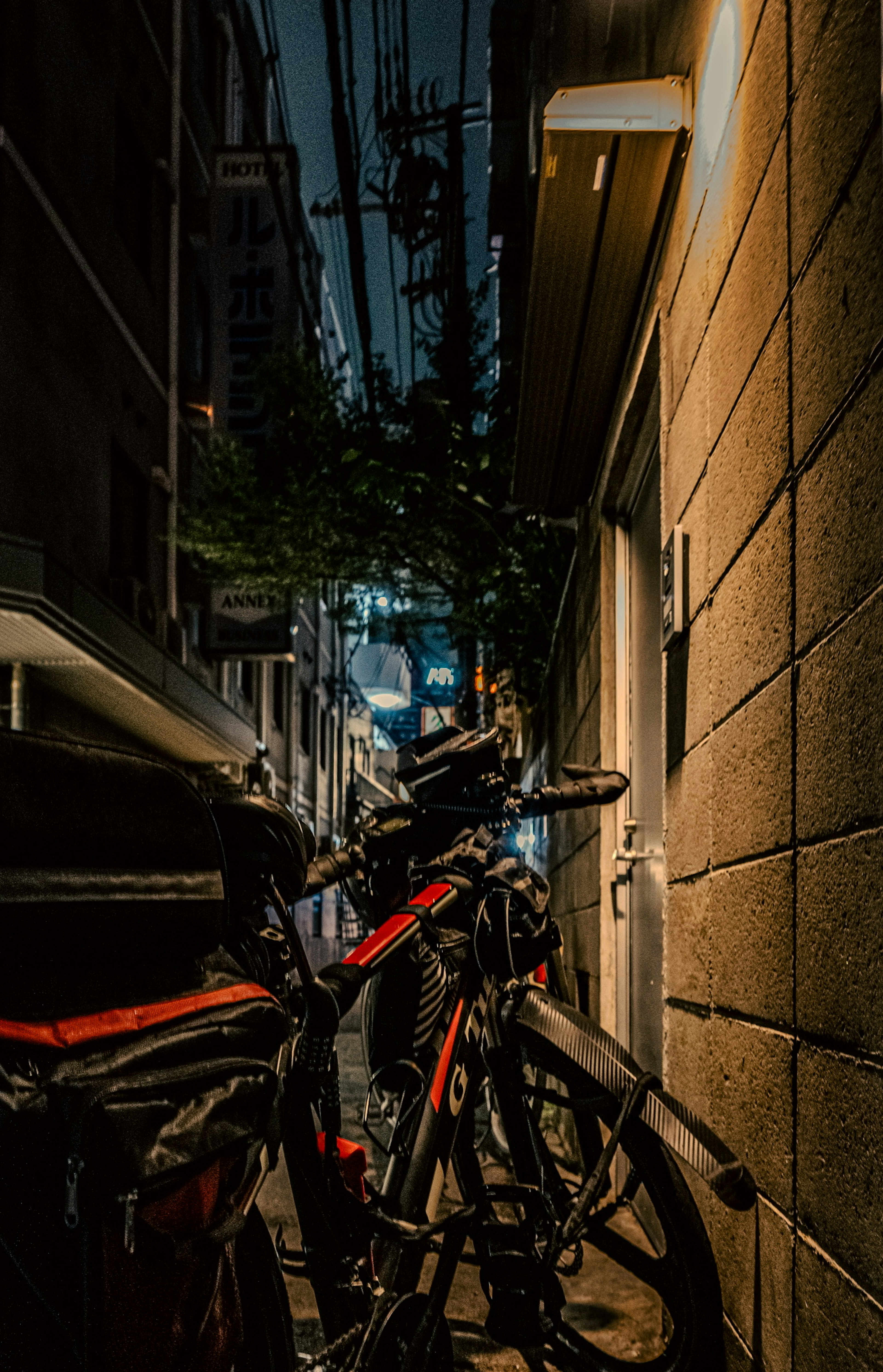 Bicicletas alineadas en un callejón estrecho con un fondo oscuro de noche