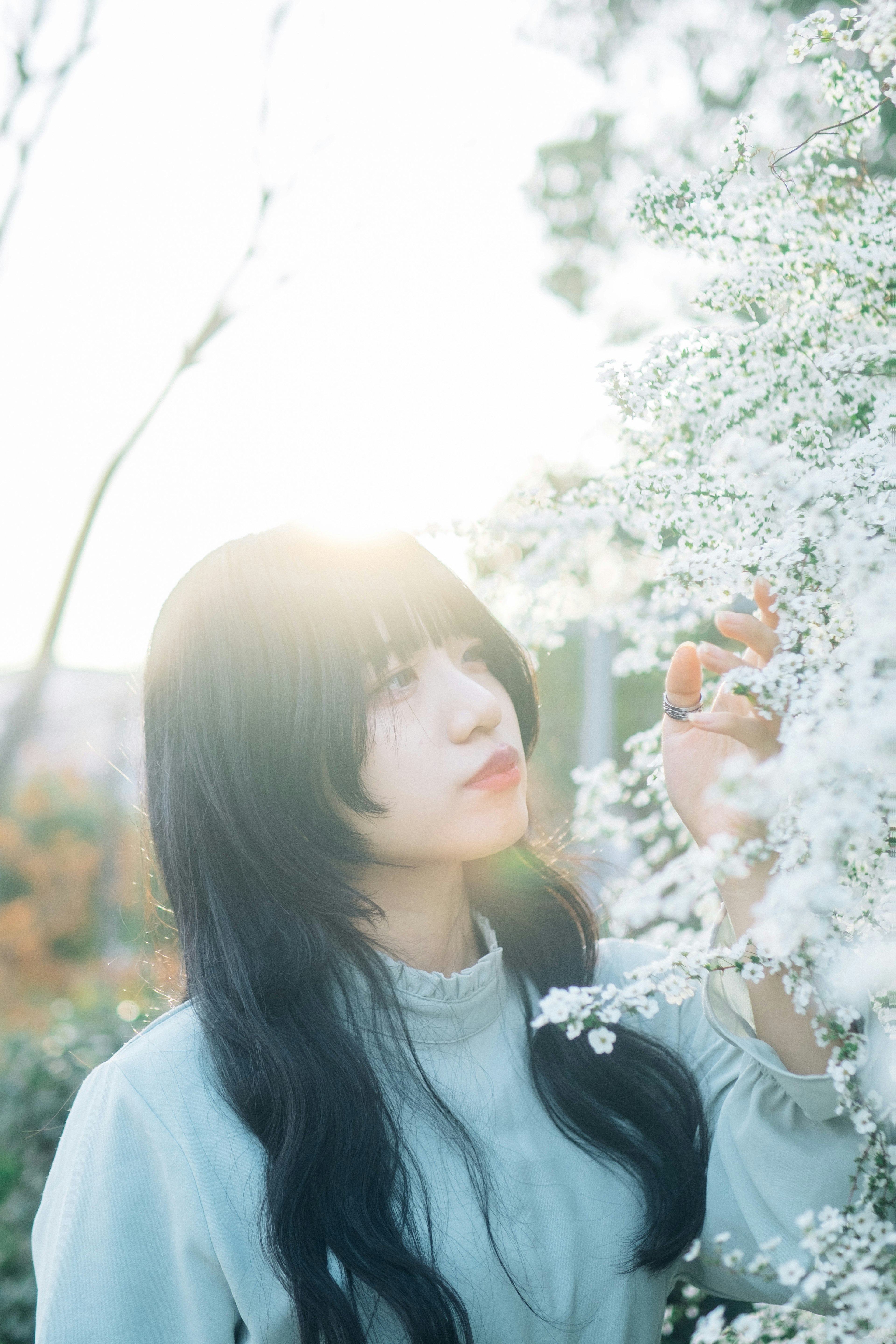 Retrato de una mujer cerca de hermosas flores blancas