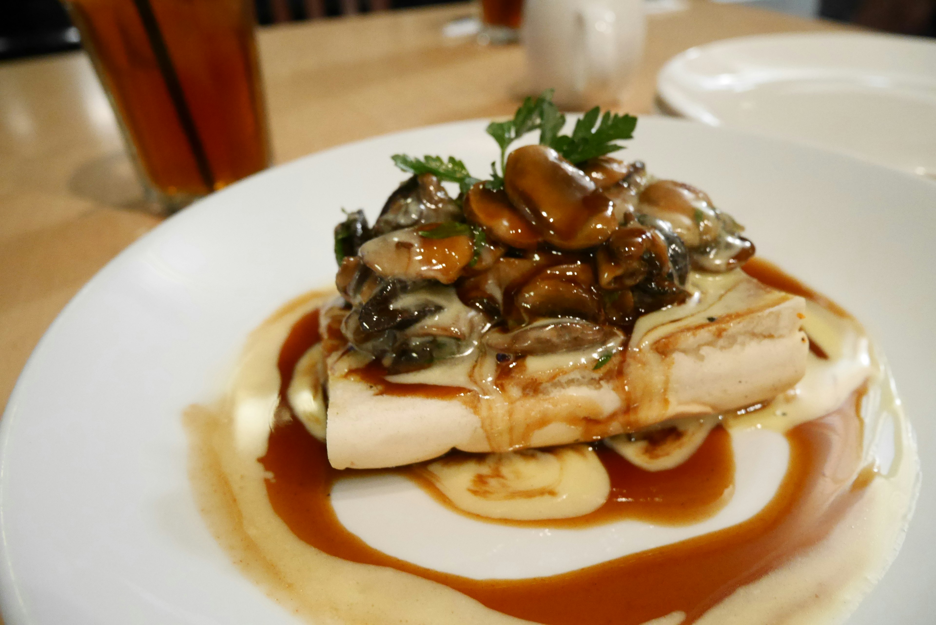 Une assiette délicieuse avec du tofu garni de champignons et de sauce, décorée d'herbes