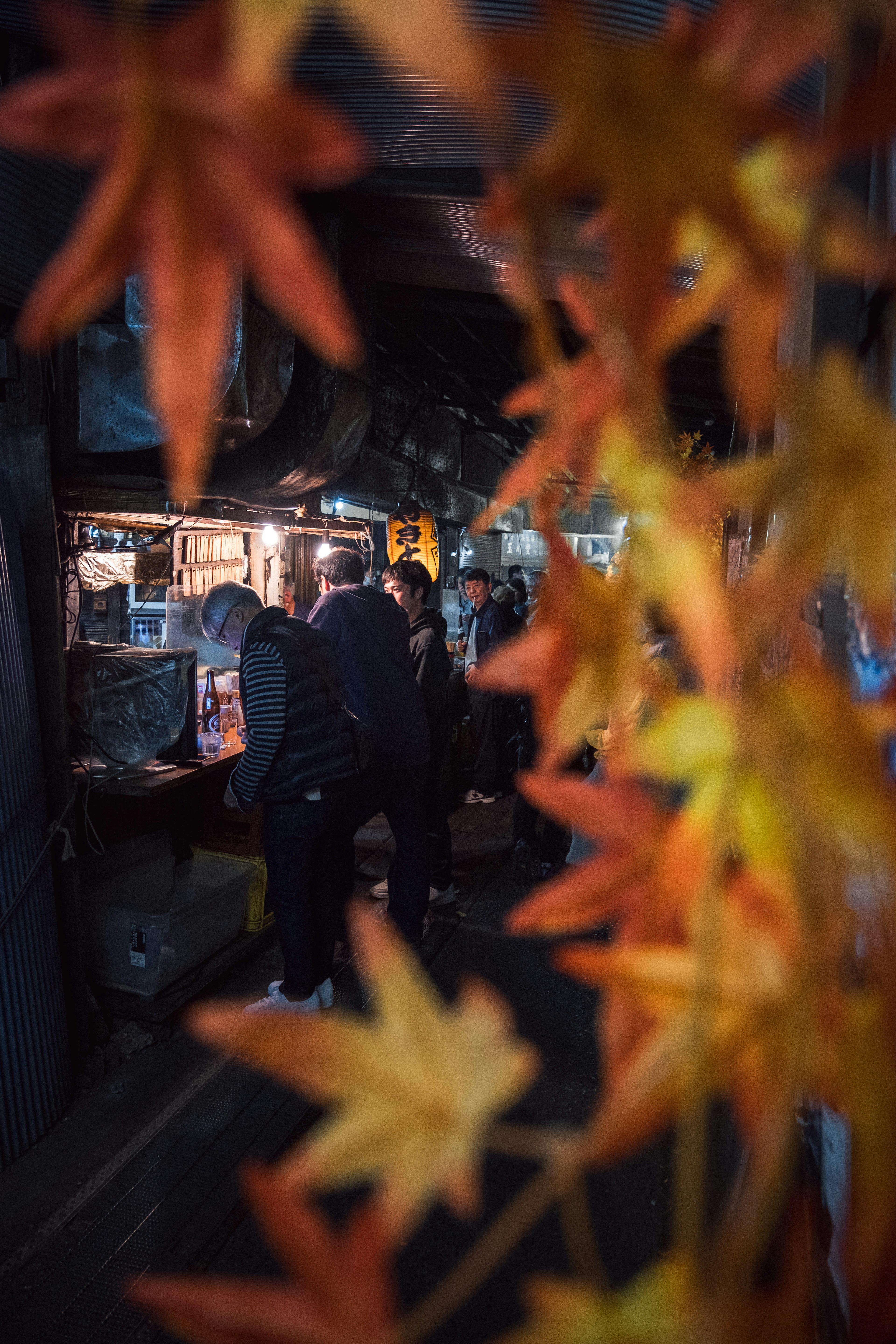 Persone che si godono una scena di mercato con decorazioni di foglie autunnali