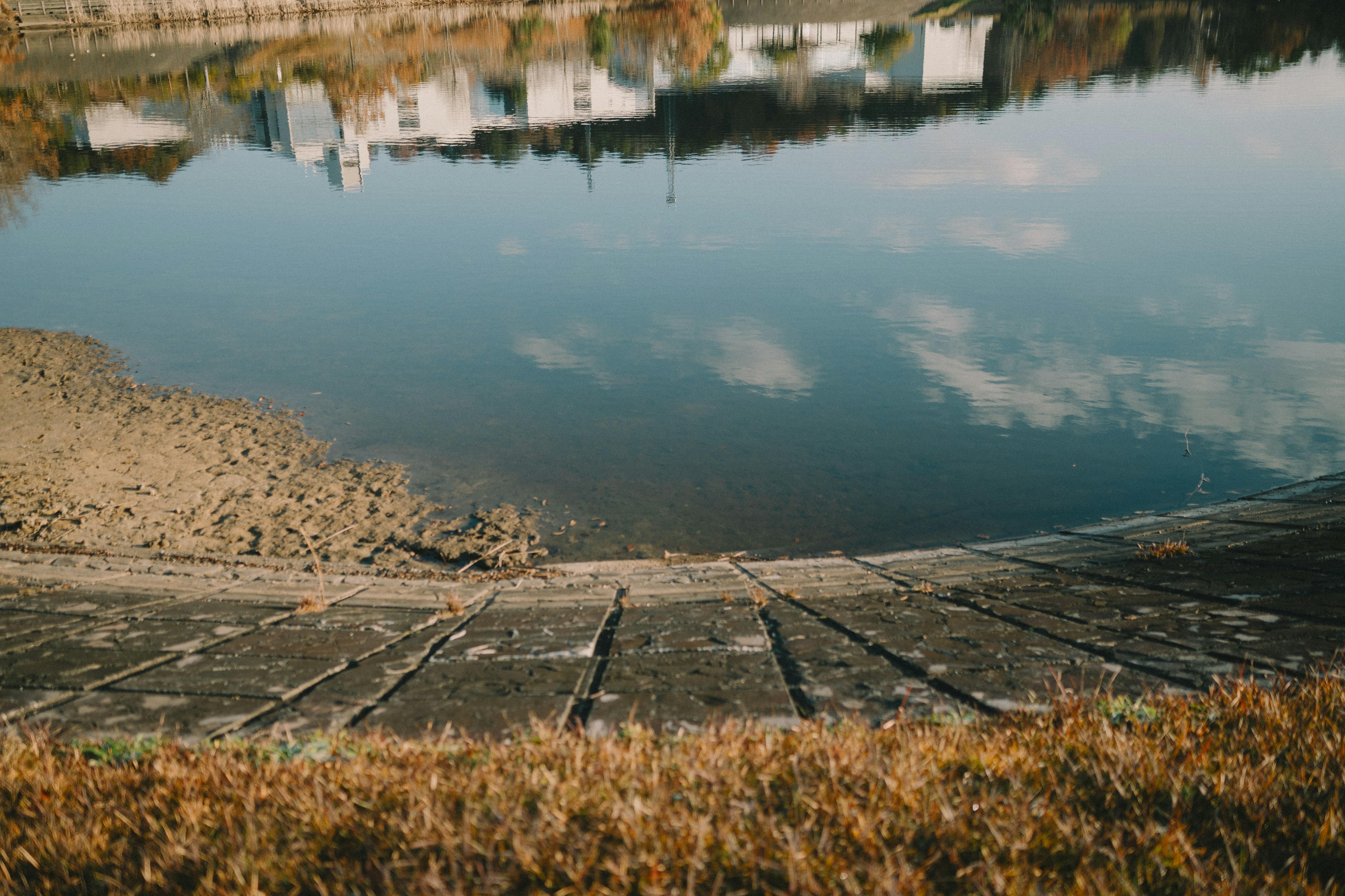 Ruhiges Wasser, das weiße Gebäude und blauen Himmel spiegelt