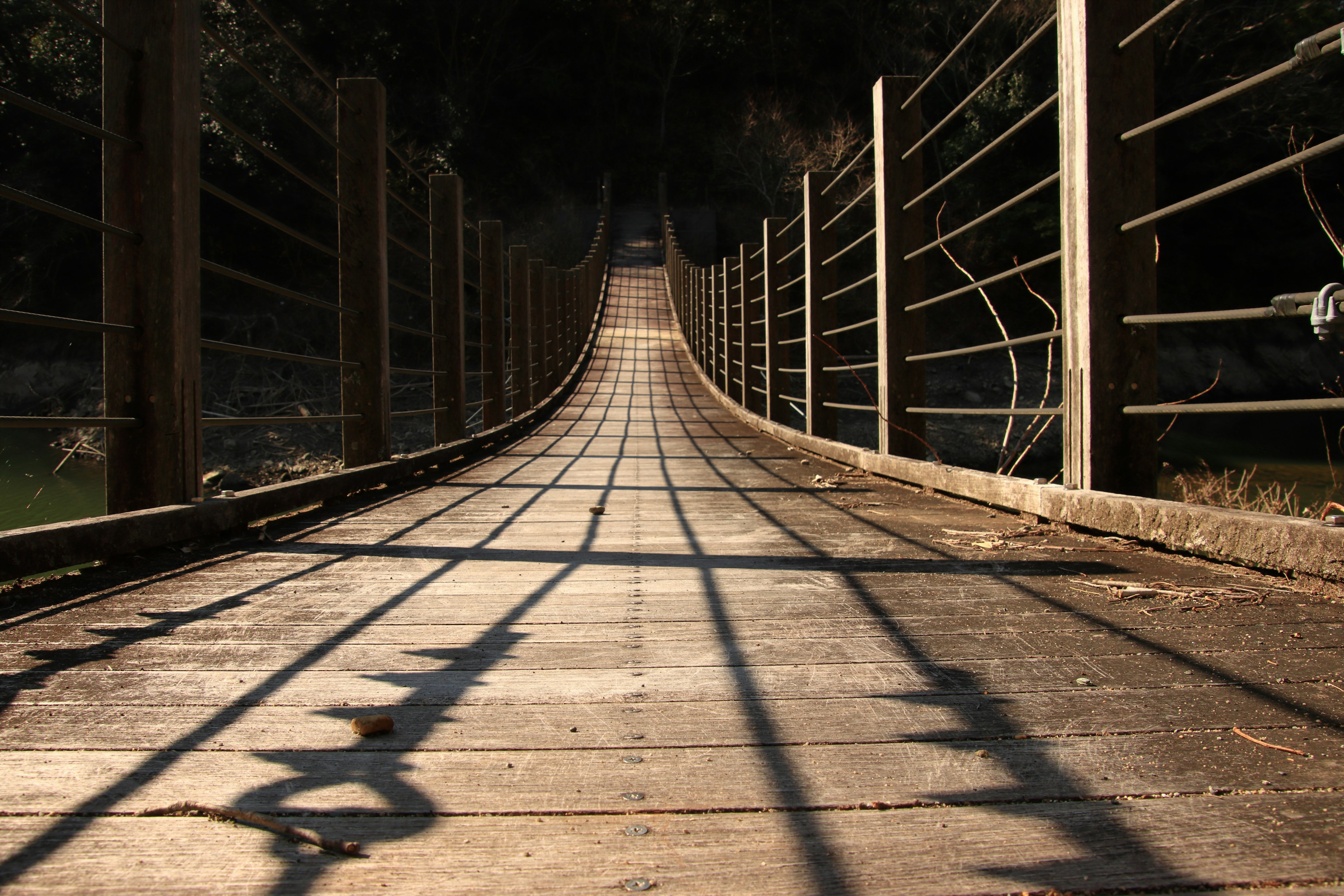 Vue en perspective d'un pont en bois avec des ombres allongées