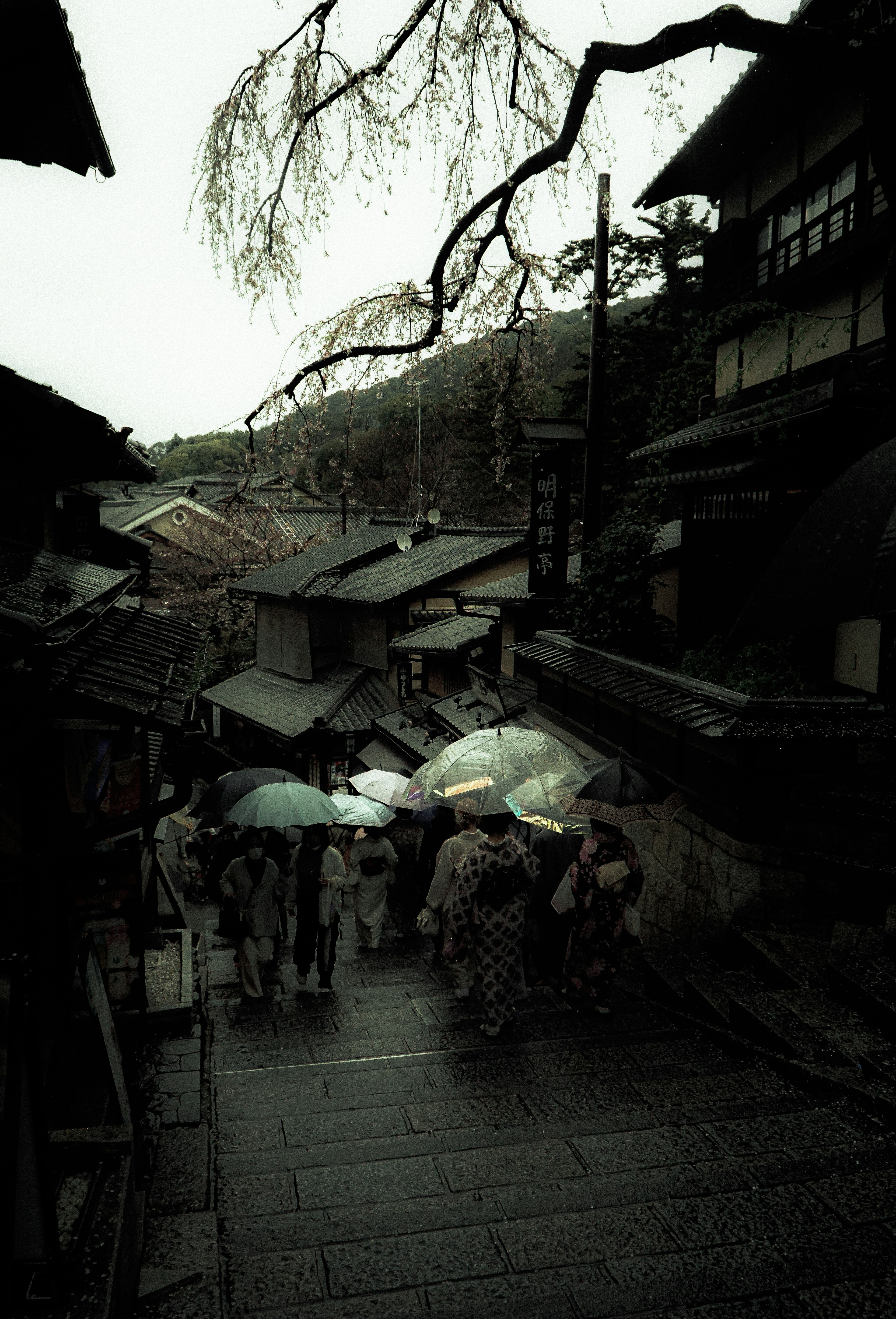 People walking with umbrellas in a historic street scene