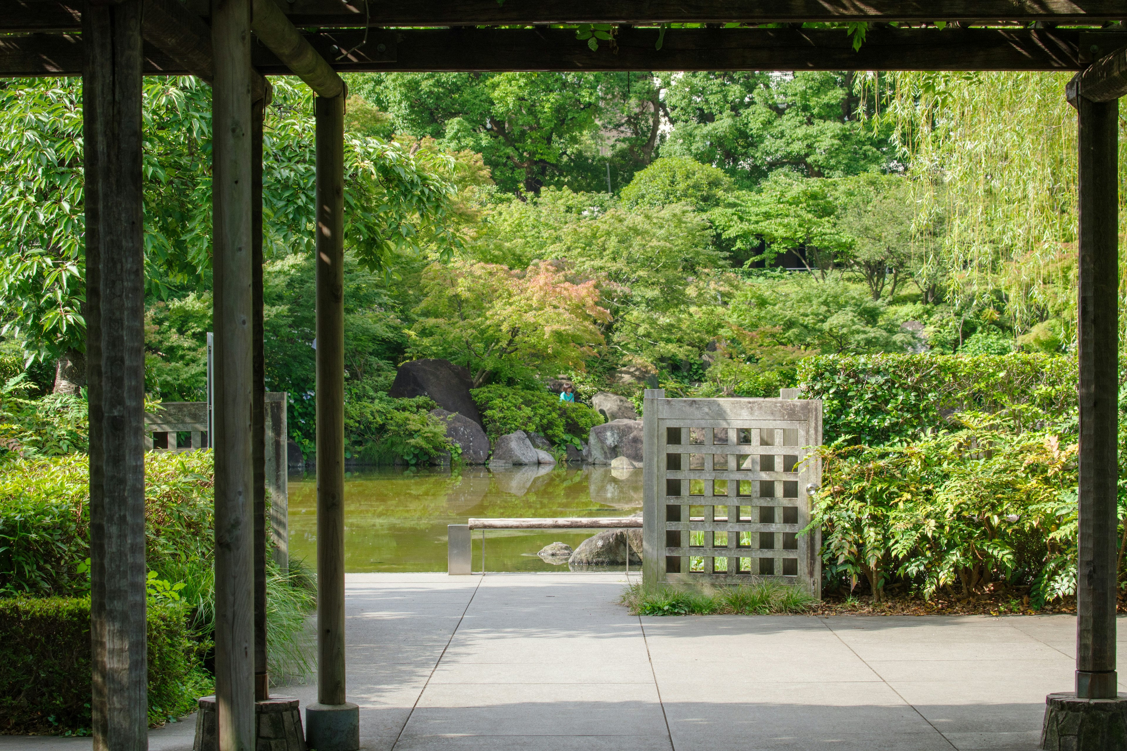 緑豊かな庭園の景色が見えるアーチの下からの眺めと水辺の風景