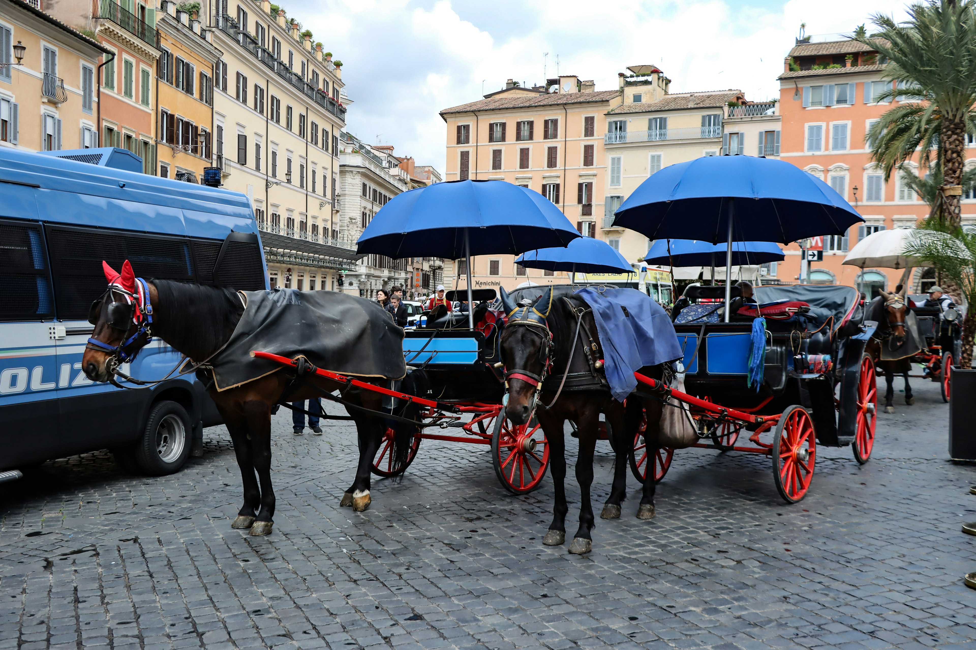 Pferdewagen mit blauen Regenschirmen in einem römischen Platz