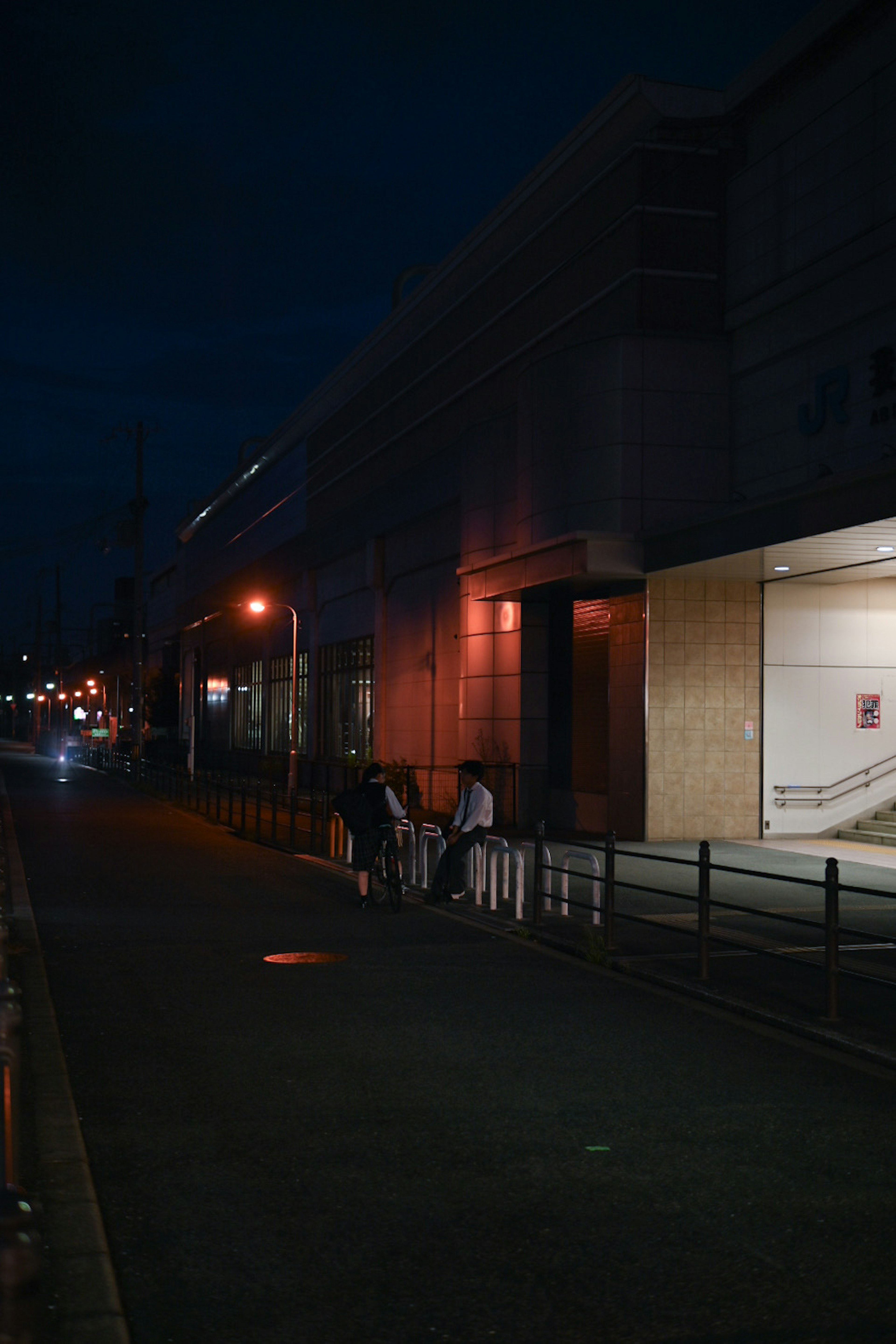 夜の街路に歩く人々と建物の外観