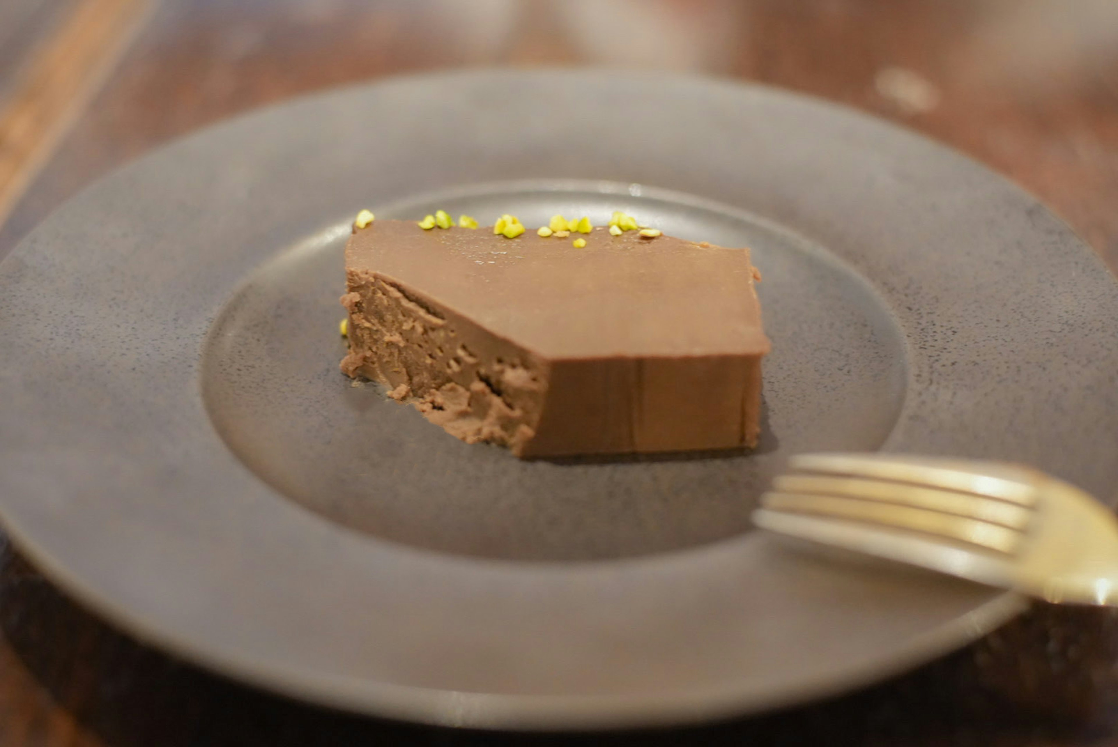 A slice of chocolate cake on a black plate