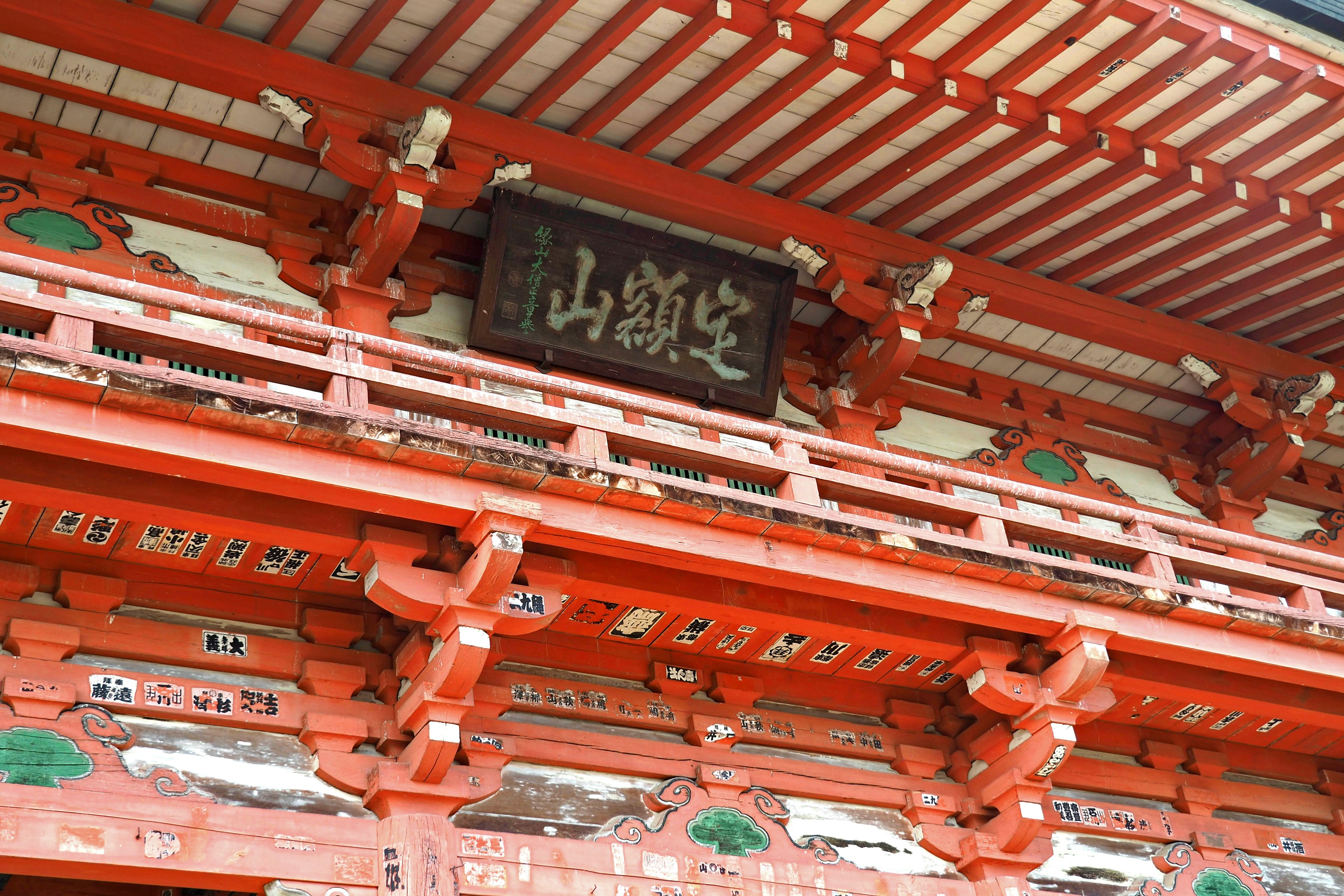 Traditional Japanese temple structure with red beams and intricate decorations