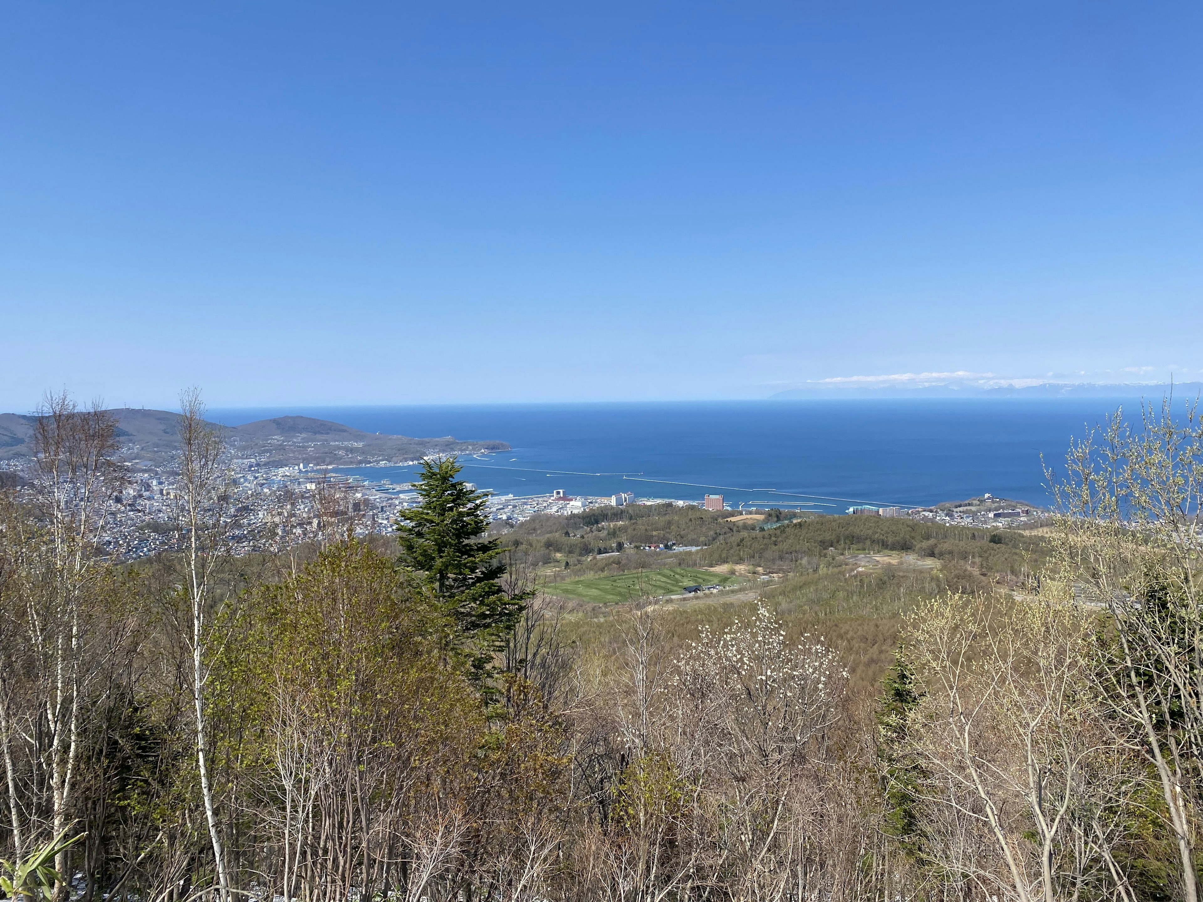 View from a mountain showing blue ocean and green hills