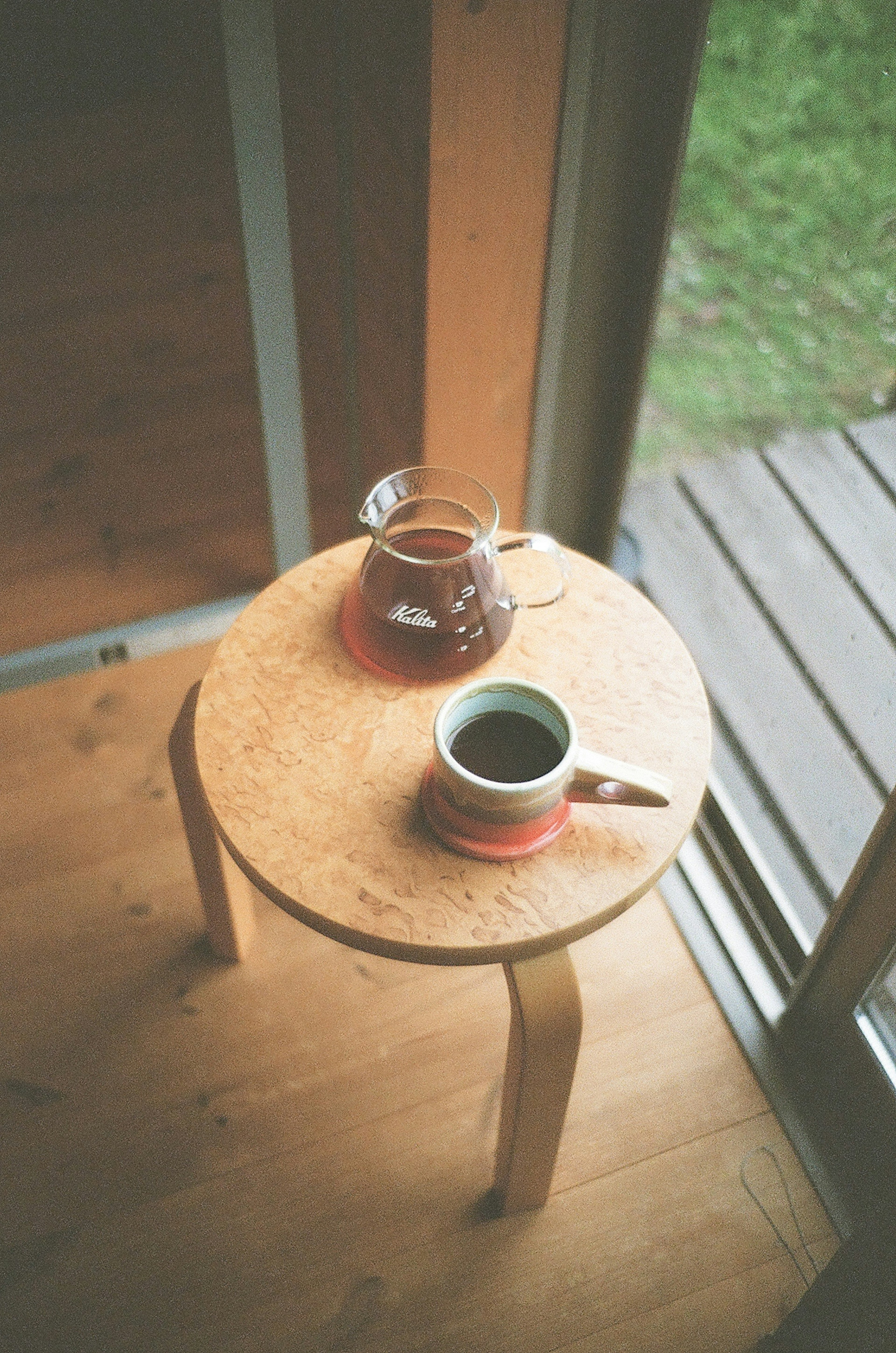 A wooden table featuring a teapot and a cup